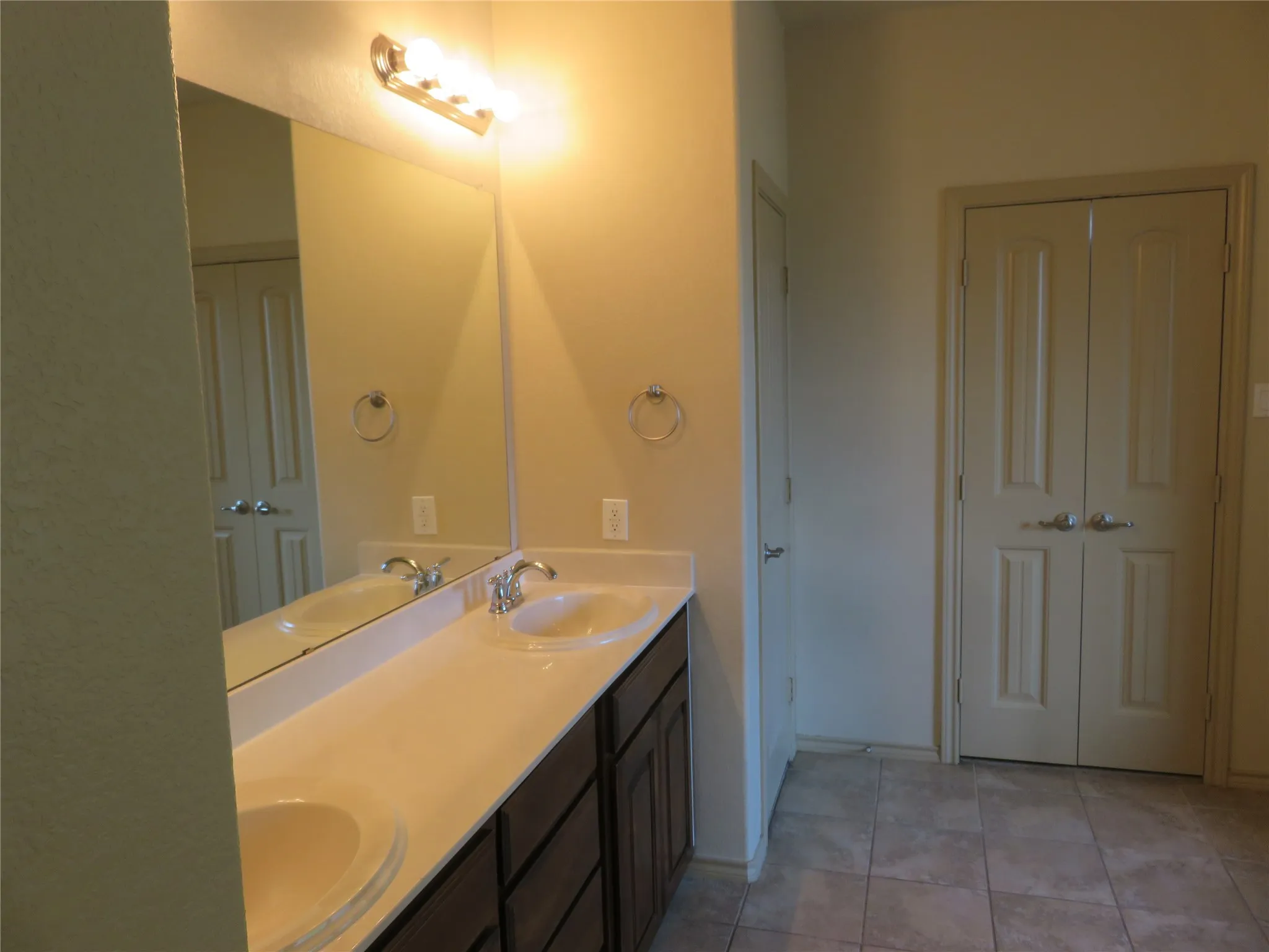 Double vanity featuring undermount sinks, chrome faucets, and a light-toned countertop