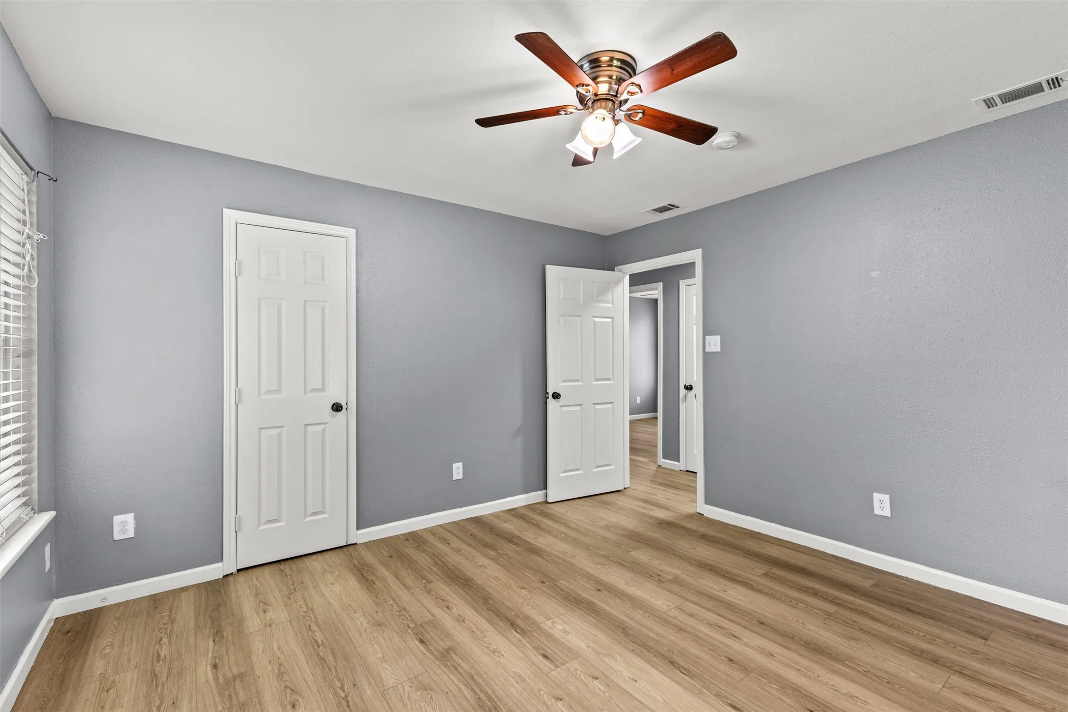 Light wood-finish flooring complements the neutral wall tones