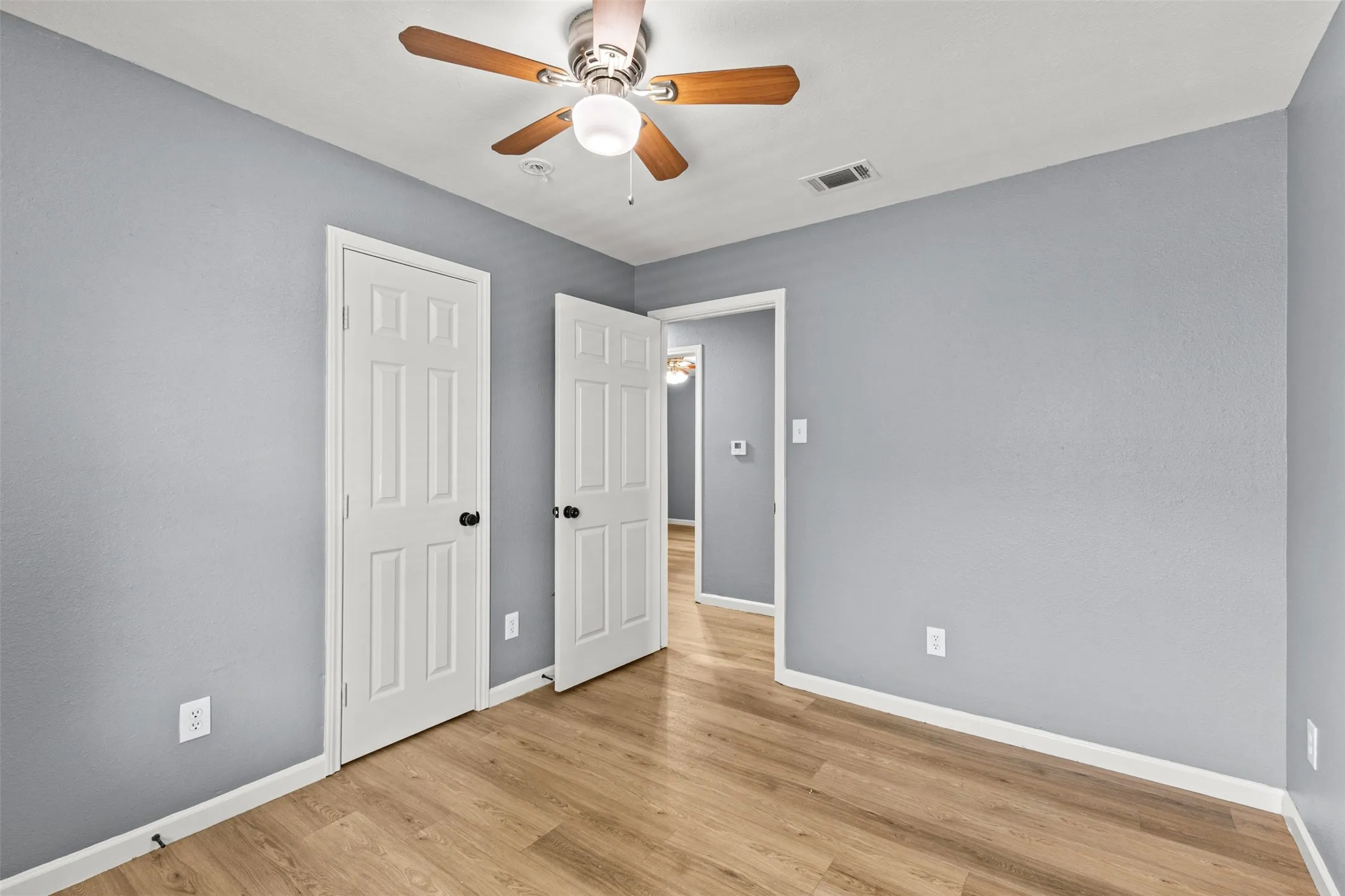 Room featuring light wood-finish flooring and light gray painted walls