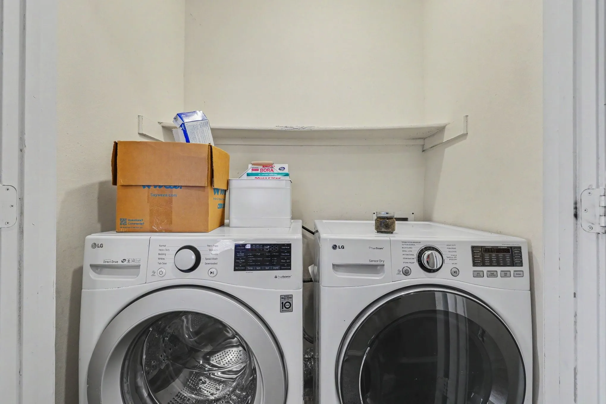 Dedicated laundry closet featuring a built-in shelf