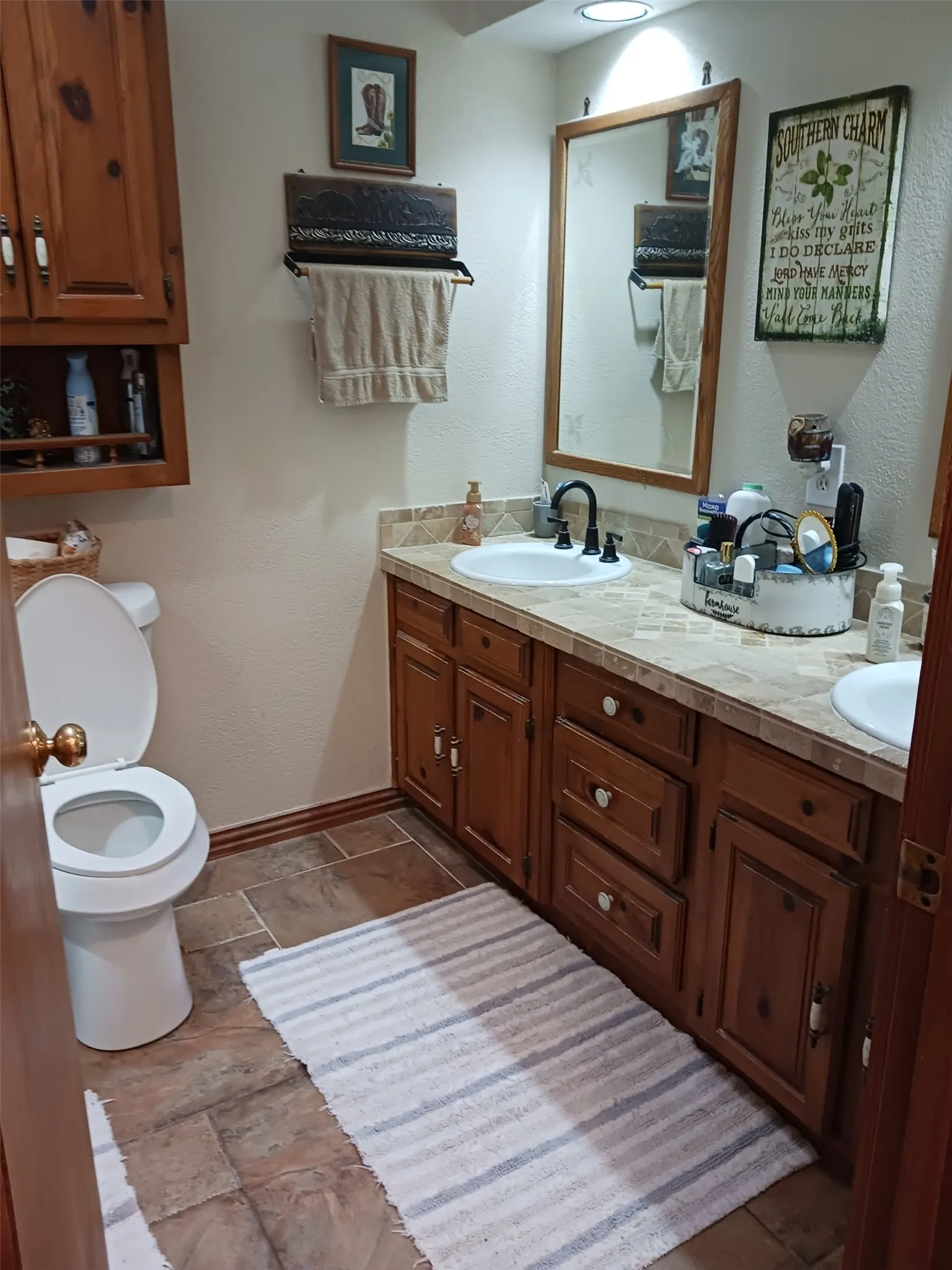 Dedicated laundry area featuring overhead wood cabinetry and a built-in shelving unit providing storage solutions