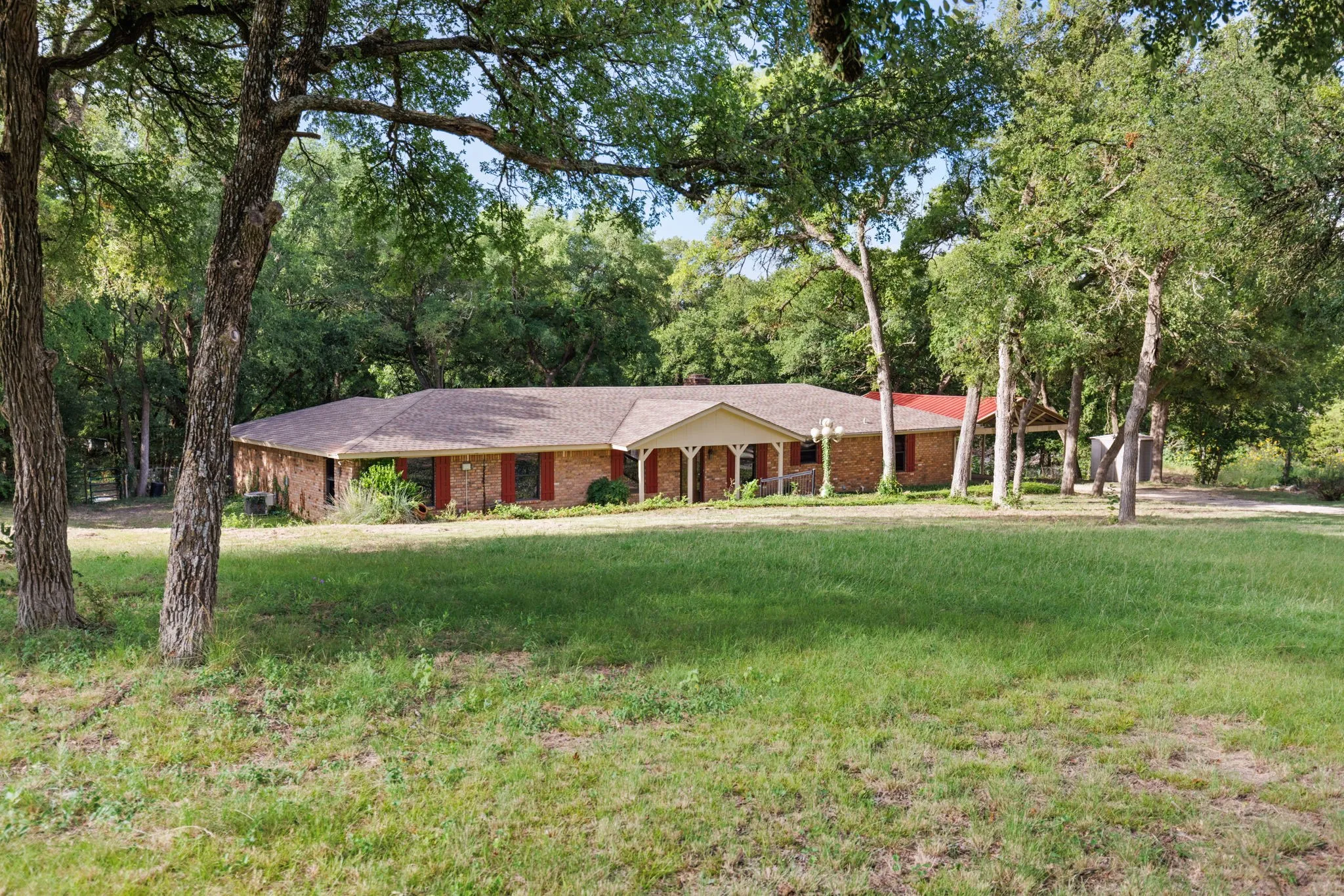 Expansive front lawn bordered by mature trees