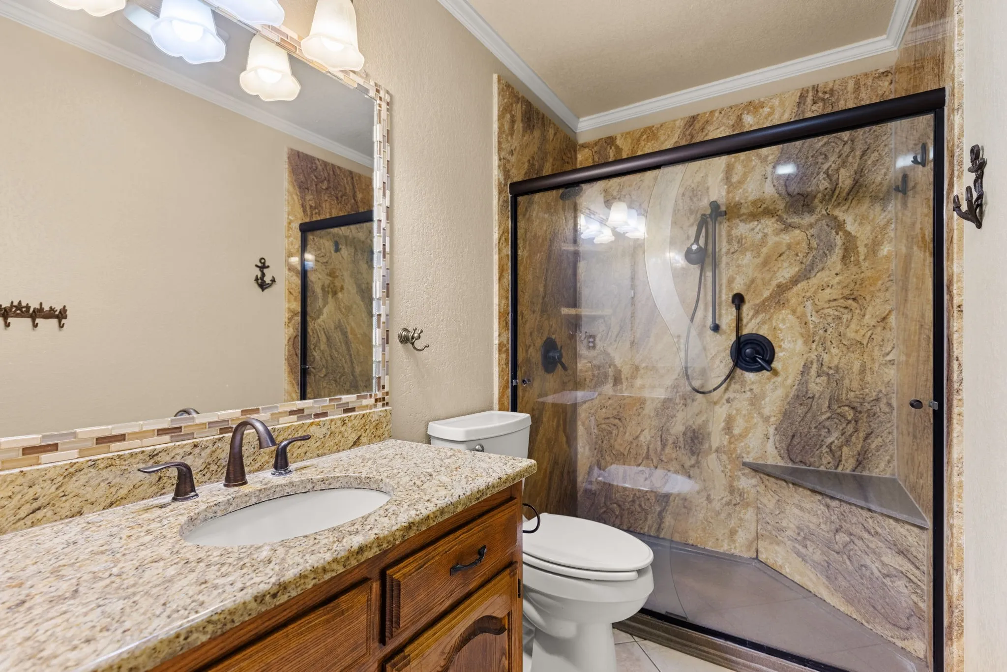 Walk-in shower with natural stone-look wall panels and a built-in bench