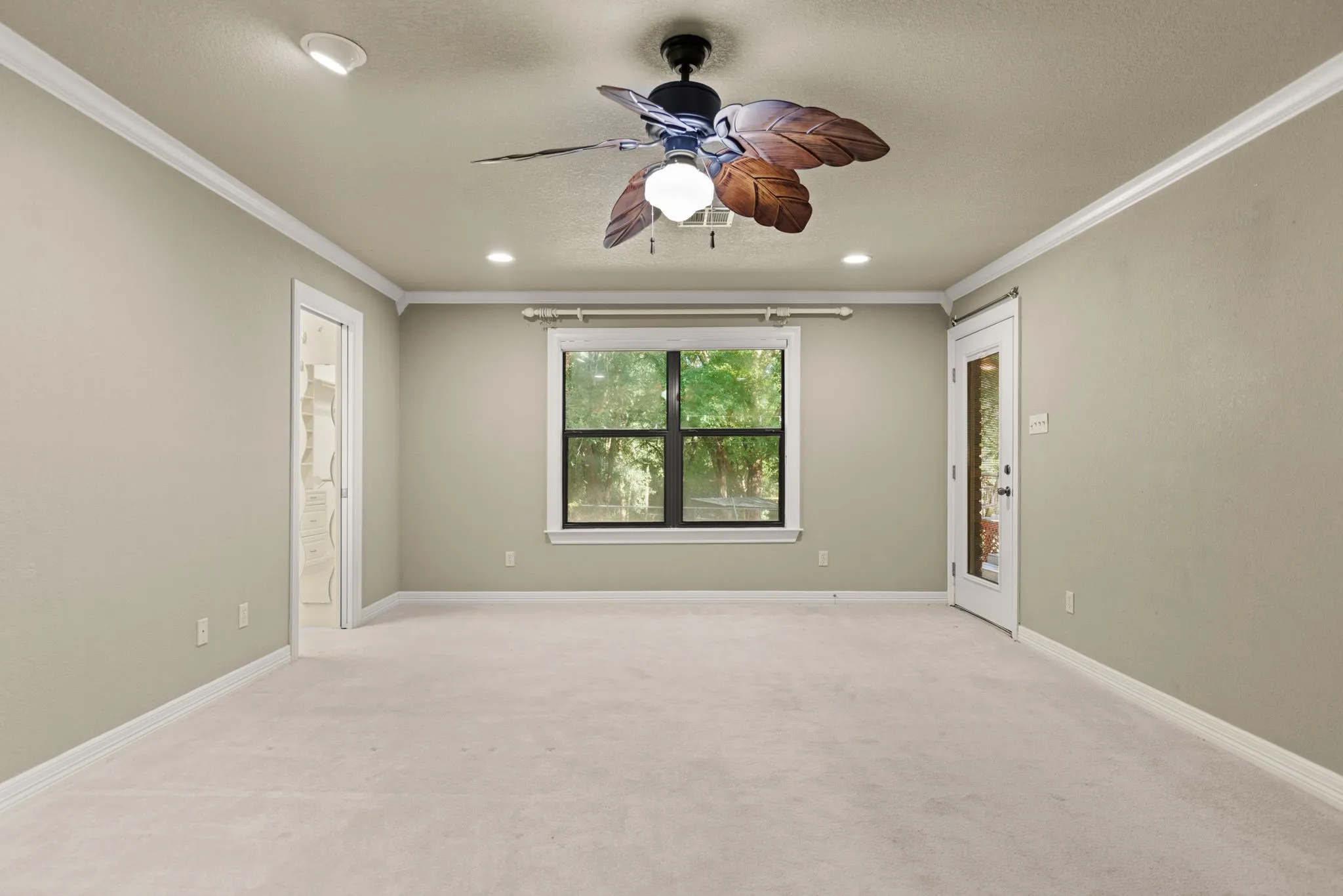 Carpeted room featuring a ceiling fan with leaf-shaped blades, recessed lighting, and crown molding