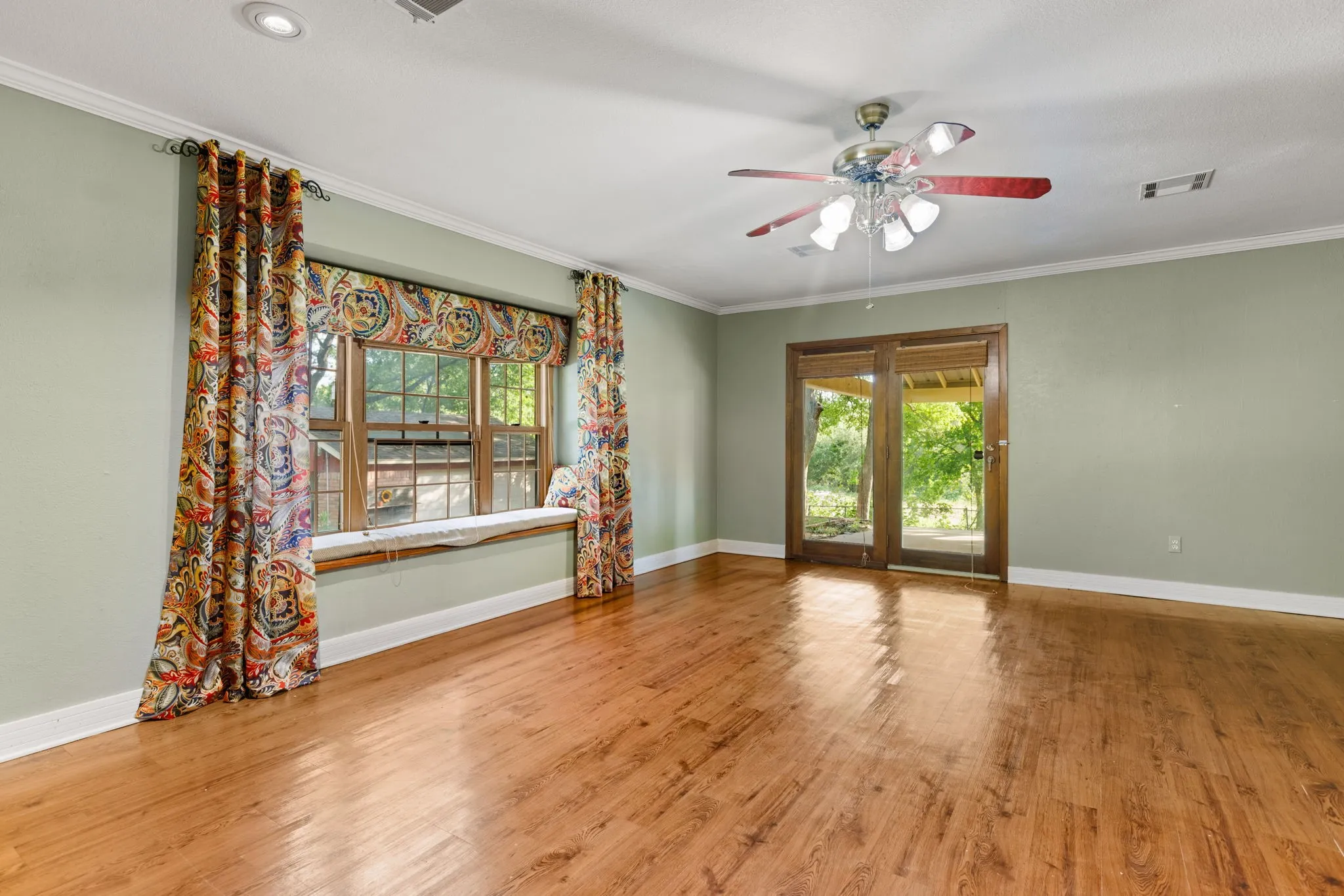 Wood-finish flooring with light green walls and white trim