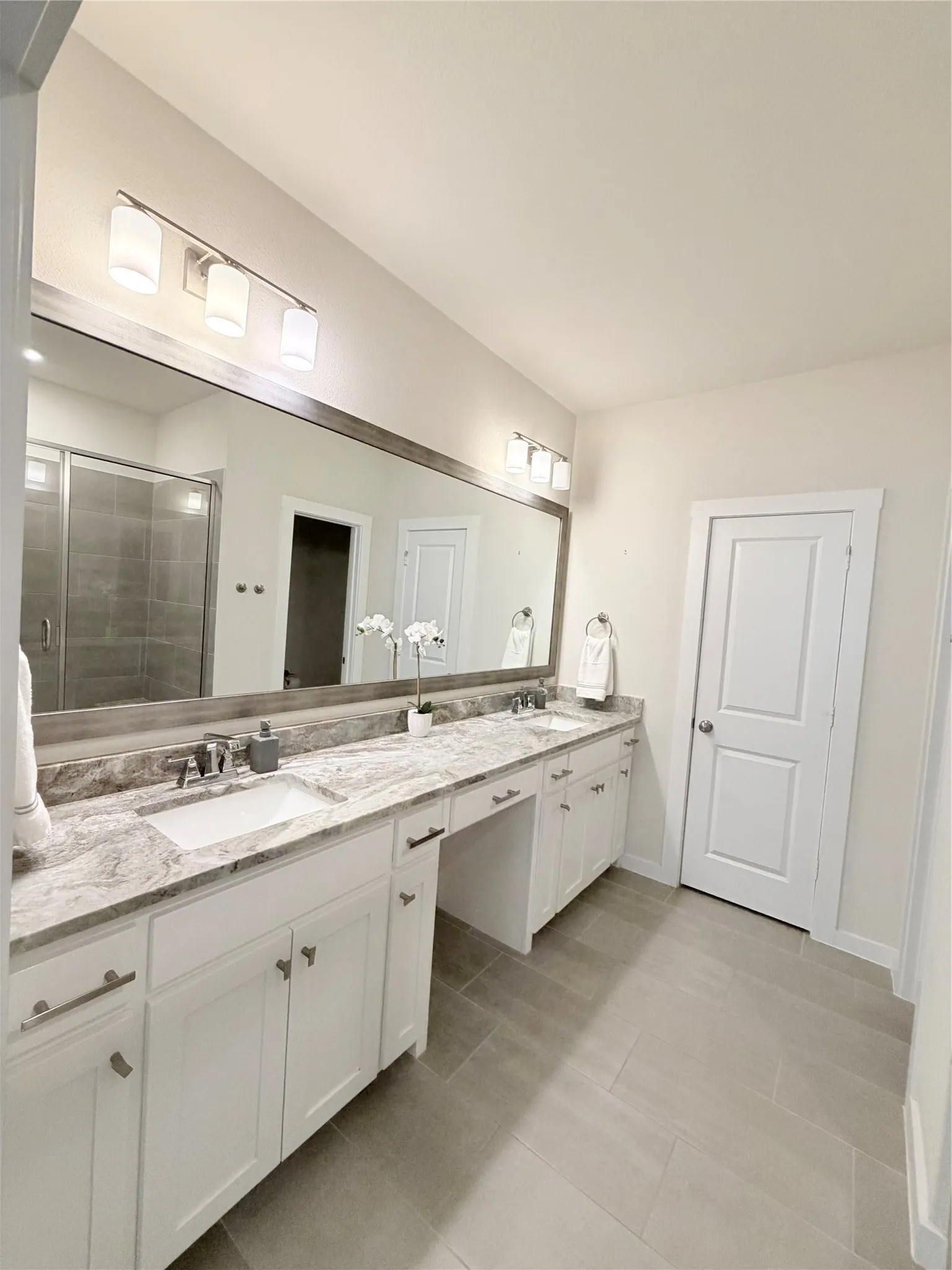 Double vanity featuring white cabinetry, undermount sinks, and a stone countertop