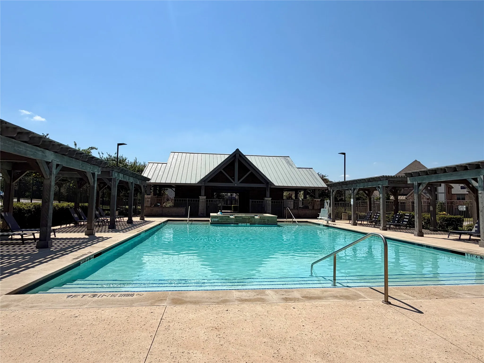 Community swimming pool with integrated spa textured concrete deck