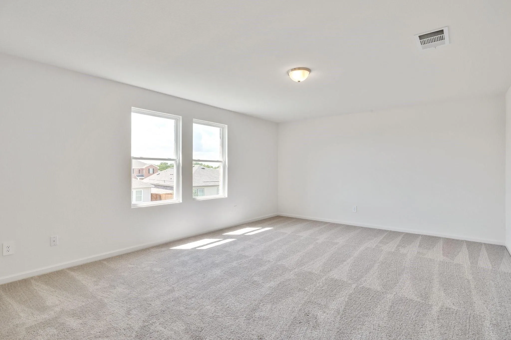 Spacious room with light gray patterned carpeting