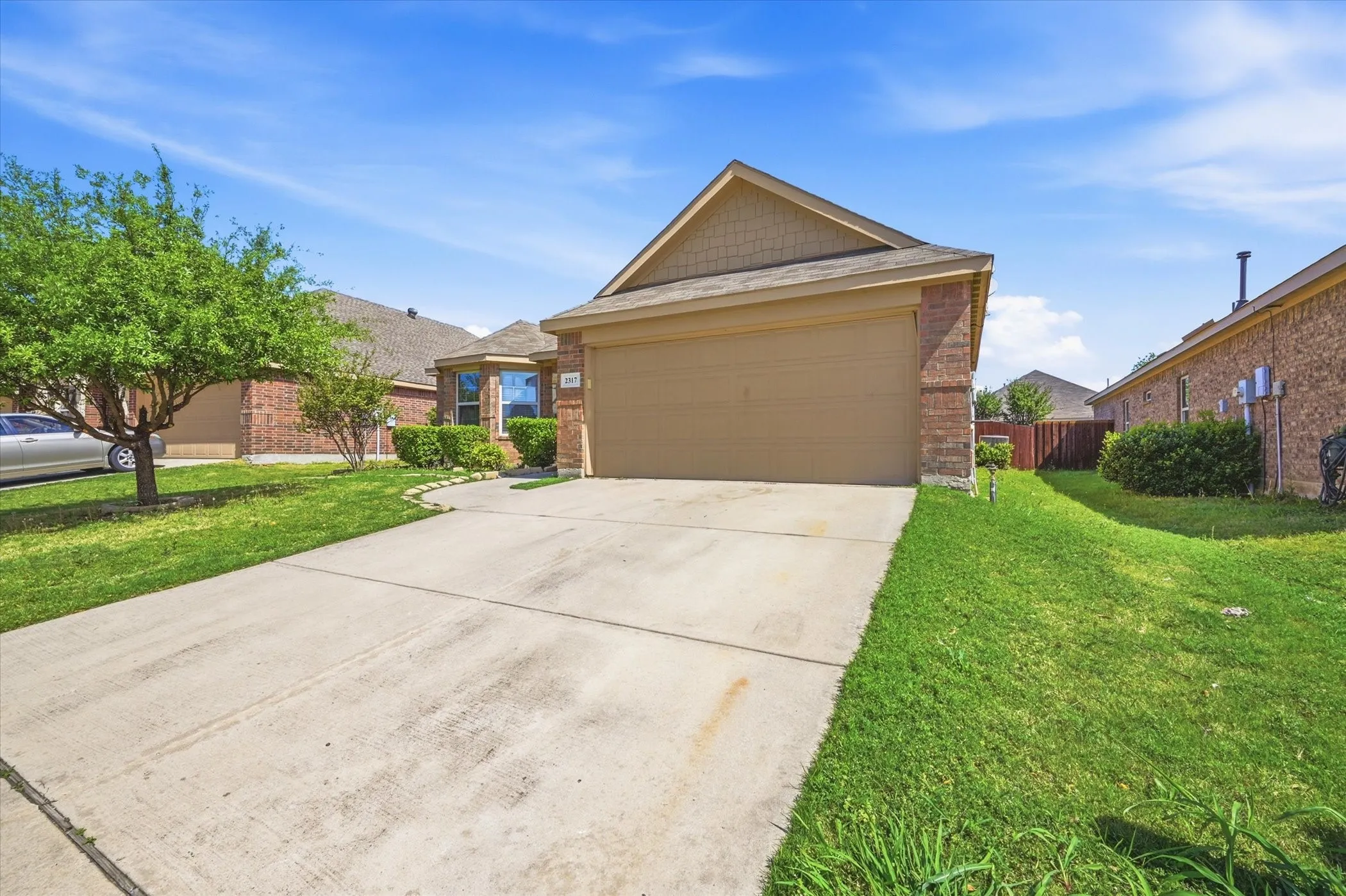 Single-story residence featuring a brick exterior and an attached two-car garage