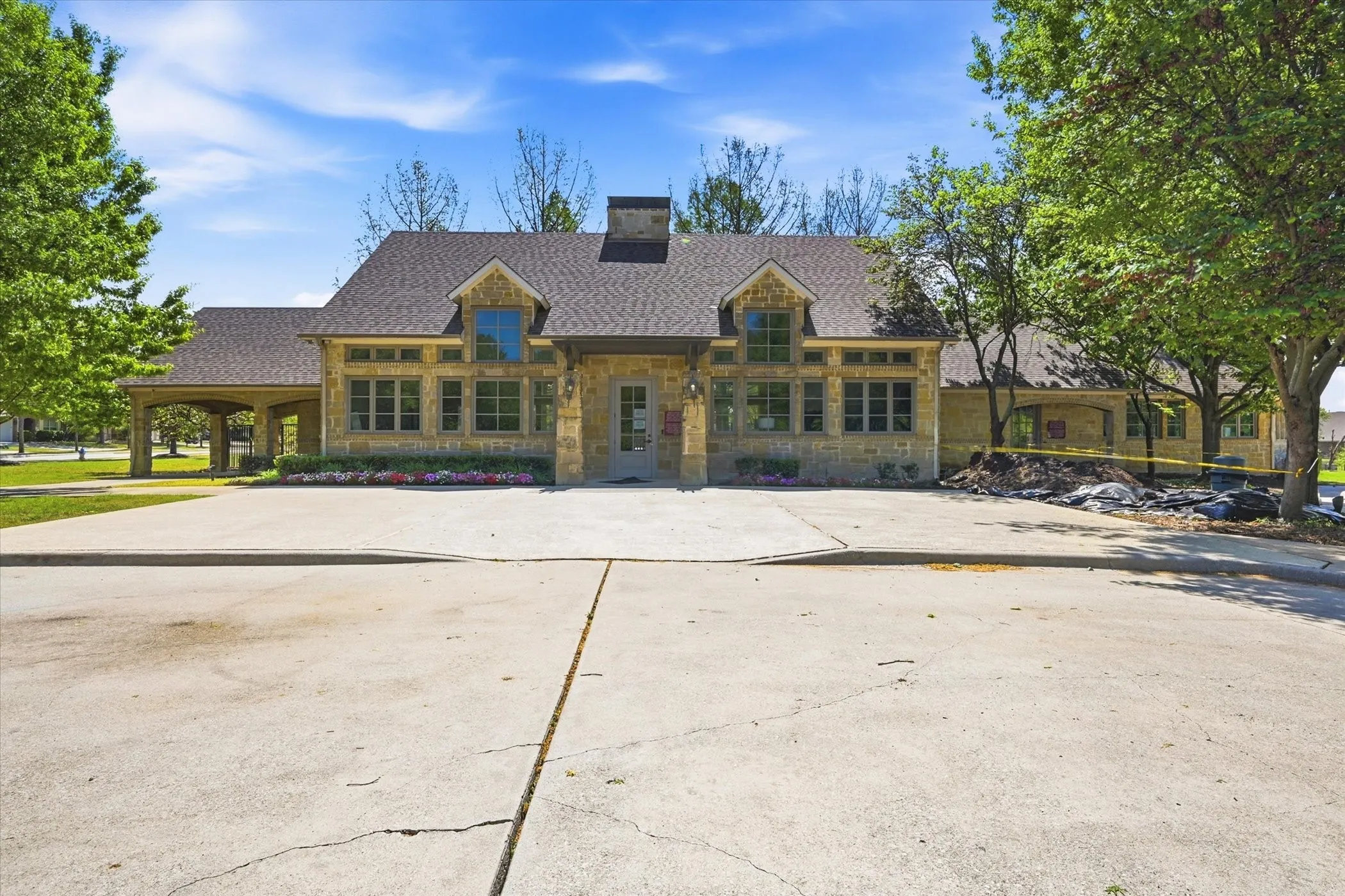 Stone facade residence featuring a steeply pitched roofline, prominent chimney, and multiple gabled dormers