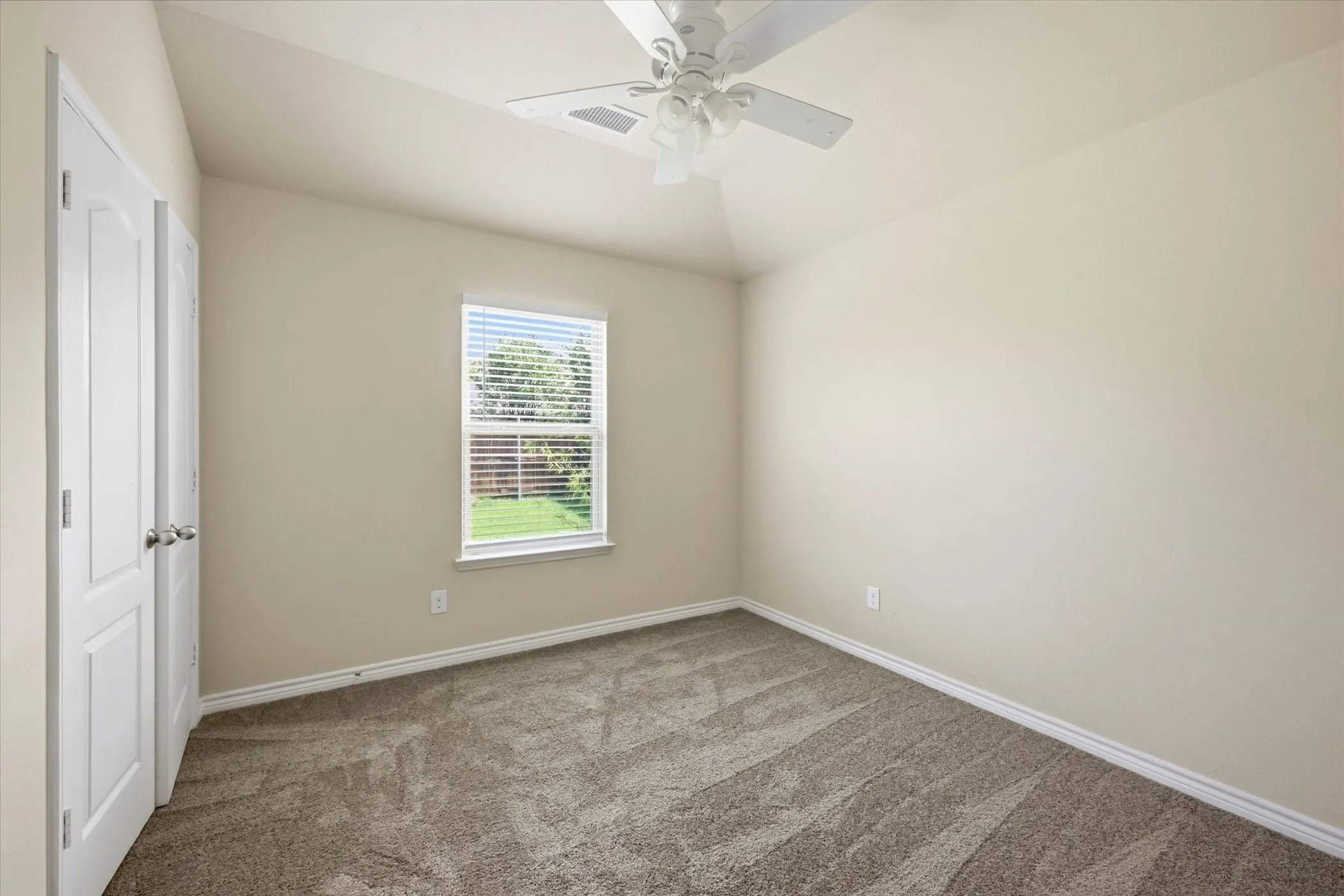 Neutral-toned walls complement the textured carpet flooring