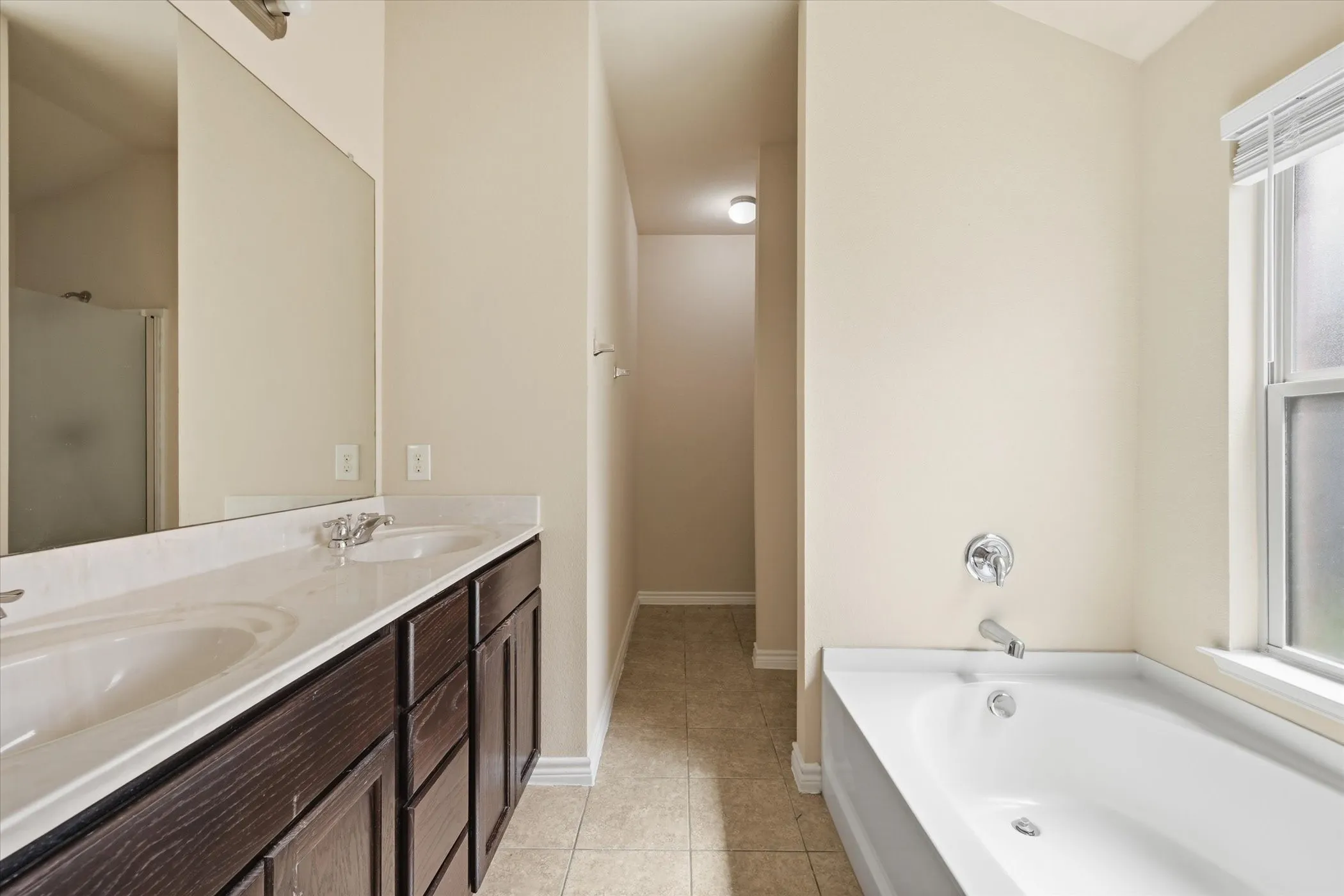Bathroom featuring a dual-sink vanity with a dark wood-finish cabinet and a light-toned countertop