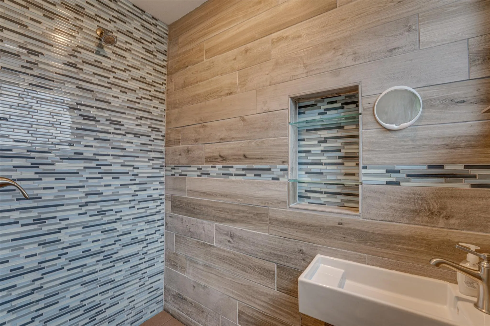 Shower with mosaic tile wall and brushed nickel fixtures