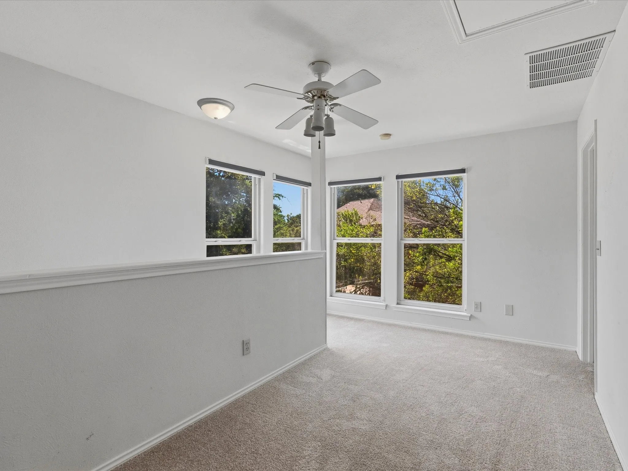Carpeted room featuring multiple windows, a ceiling fan, and recessed lighting