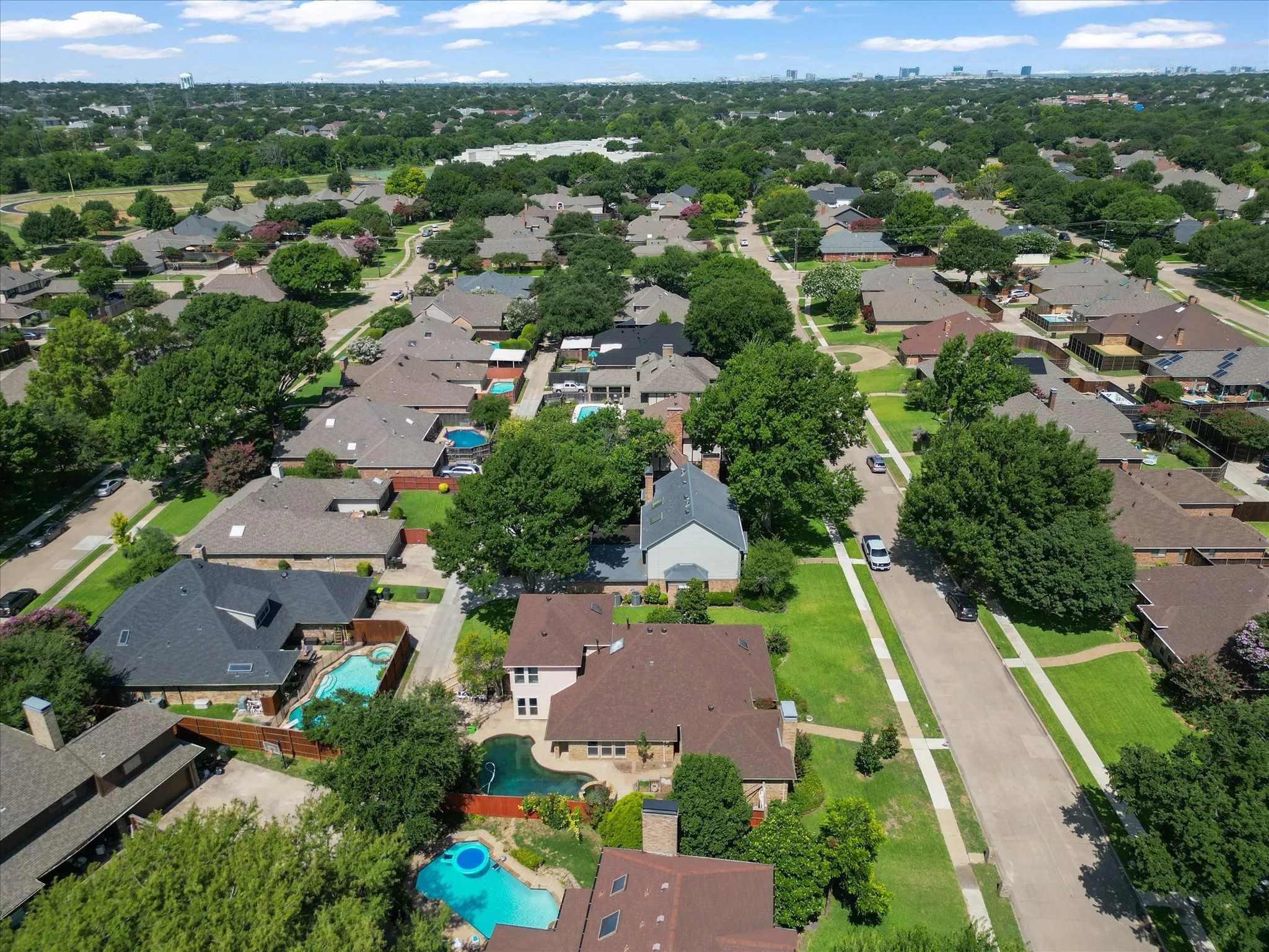 Expansive residential neighborhood featuring numerous properties with mature trees, established landscaping, and a variety of roof styles