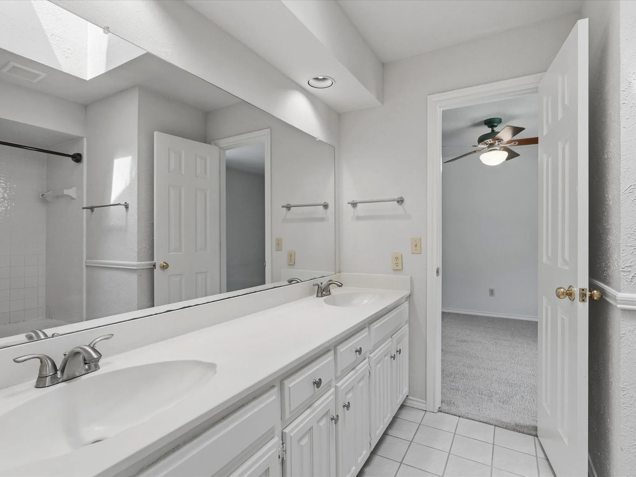 Bathroom featuring a dual vanity with integrated sinks and white cabinetry