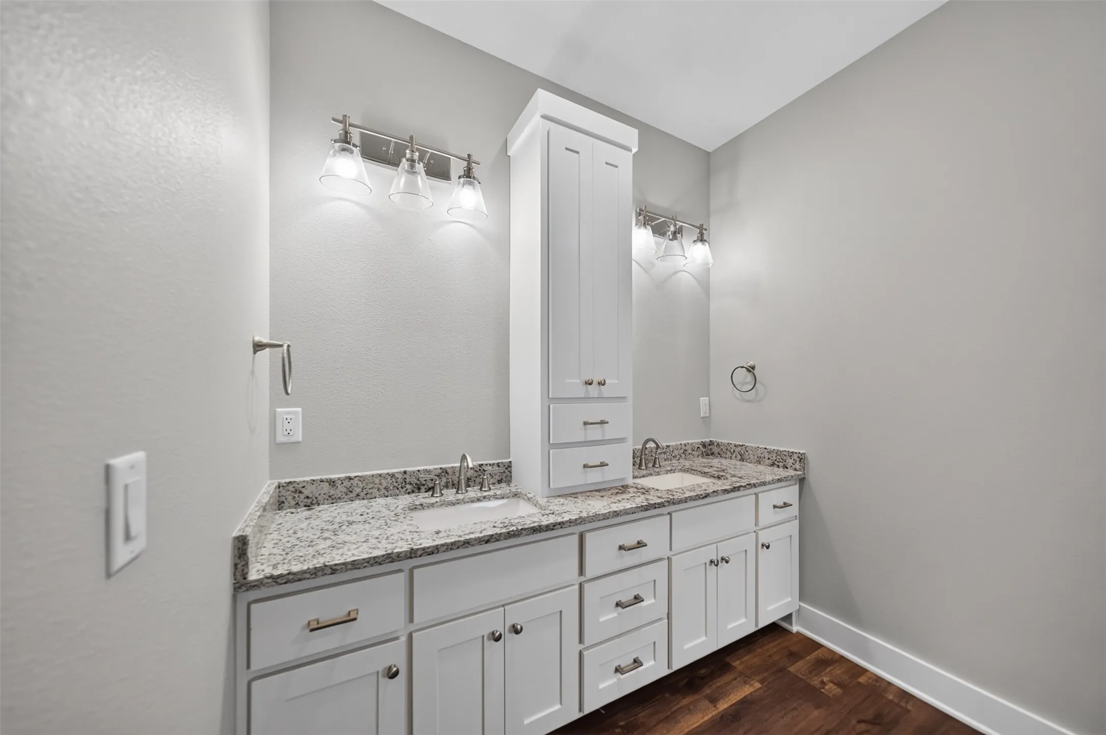 Double vanity with granite-style countertops, under-mount sinks, and white shaker-style cabinetry