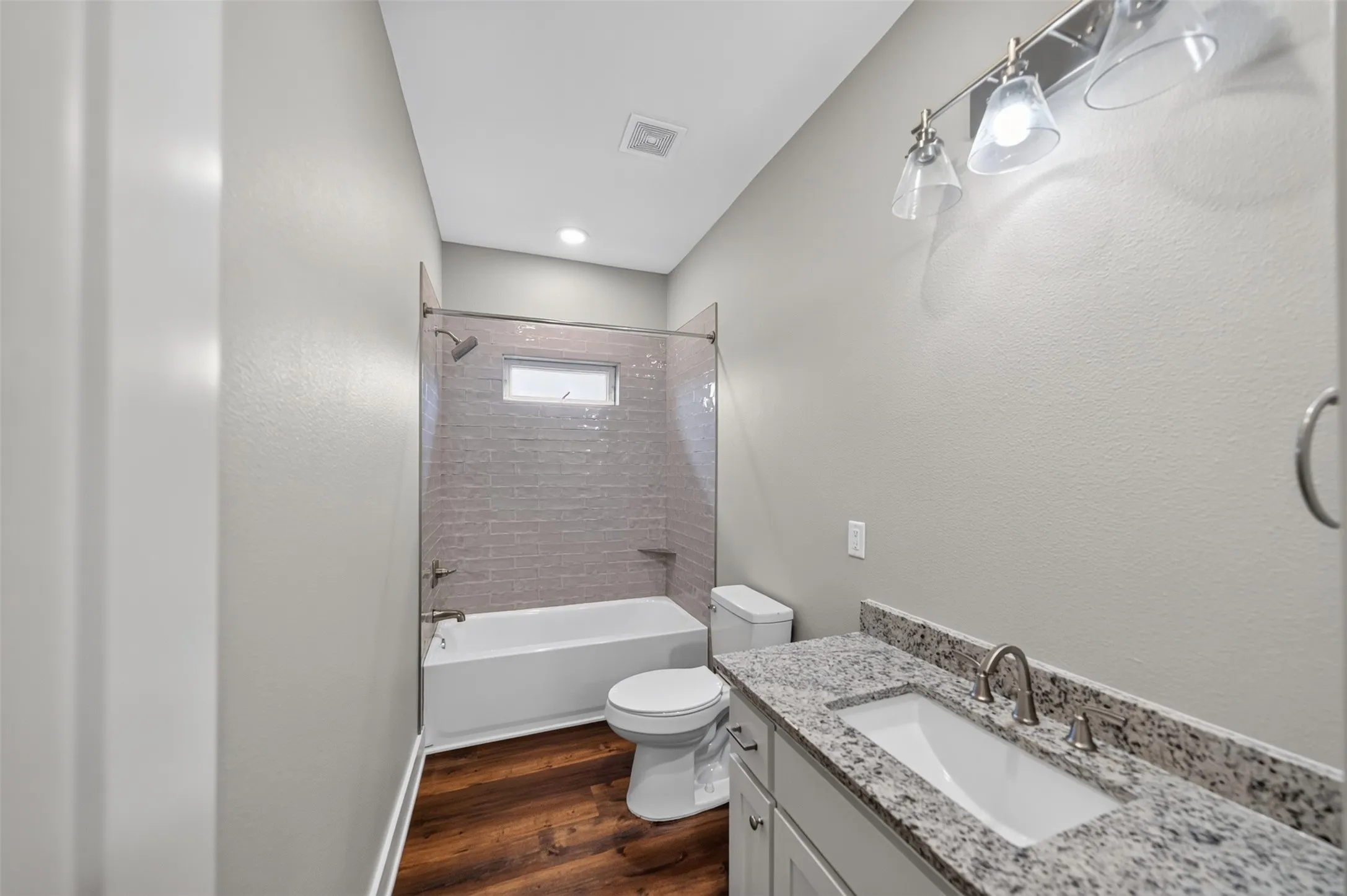 Bathroom featuring a vanity with a light granite countertop, undermount sink, and brushed nickel fixtures