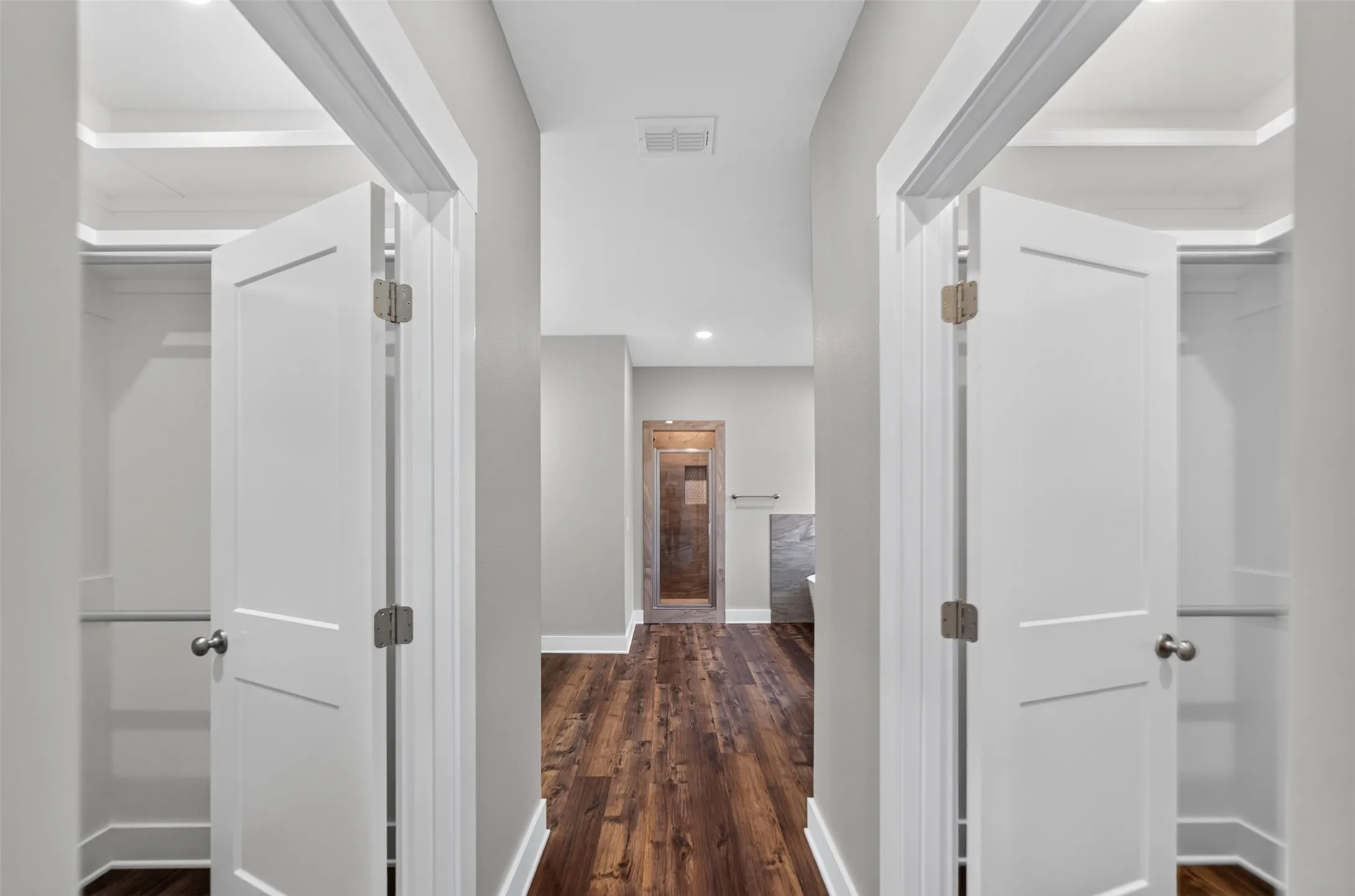 Hallway with wood-finish flooring, white trim, and recessed lighting