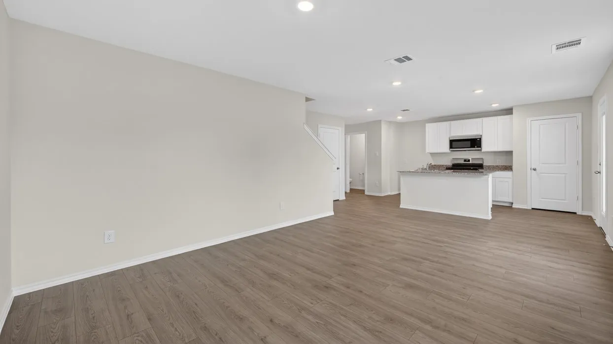 Open-concept living area with wood-finish flooring, recessed lighting, and light-toned walls