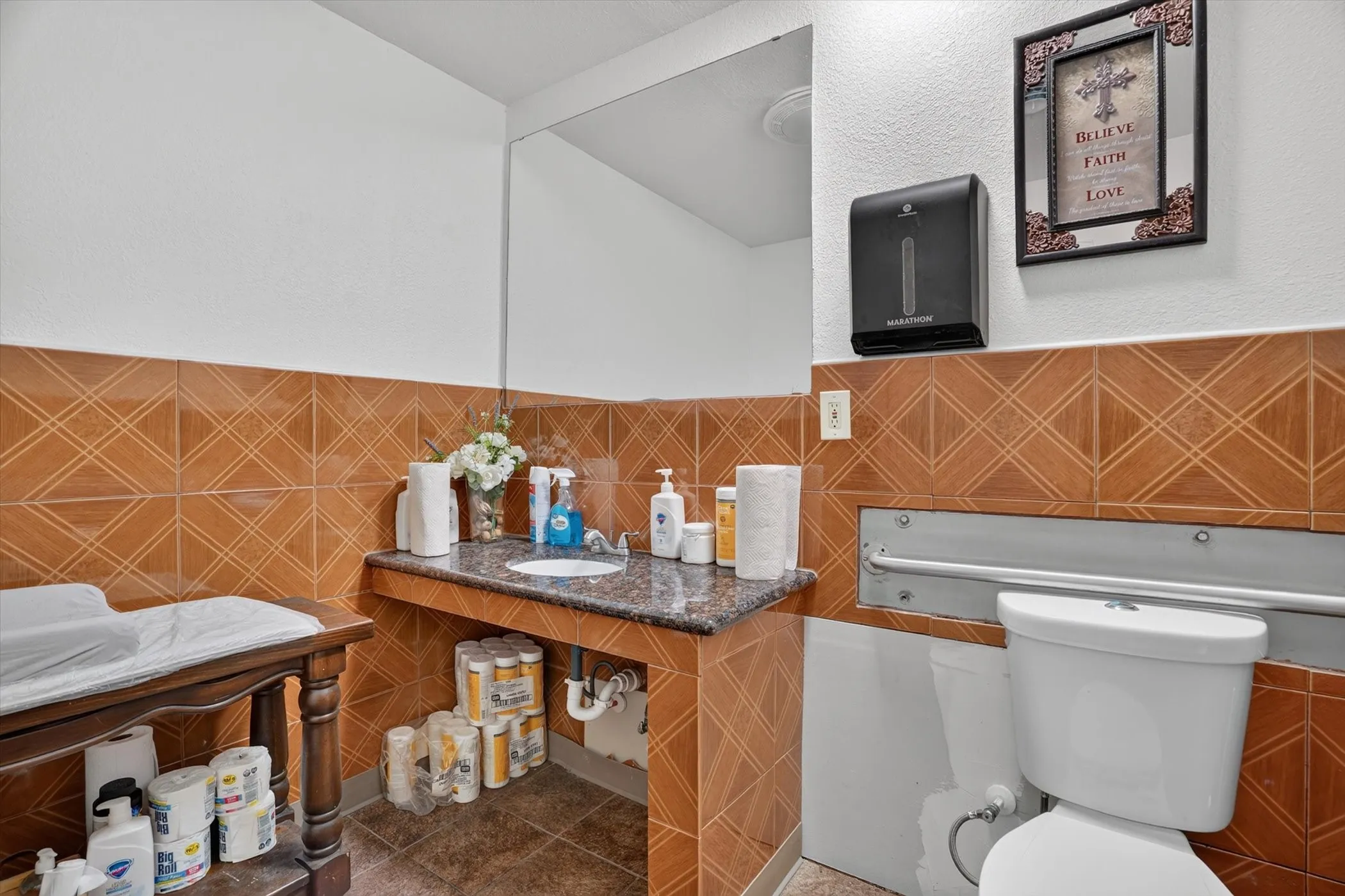 Bathroom featuring a granite-look countertop, integrated sink, and full-width mirror