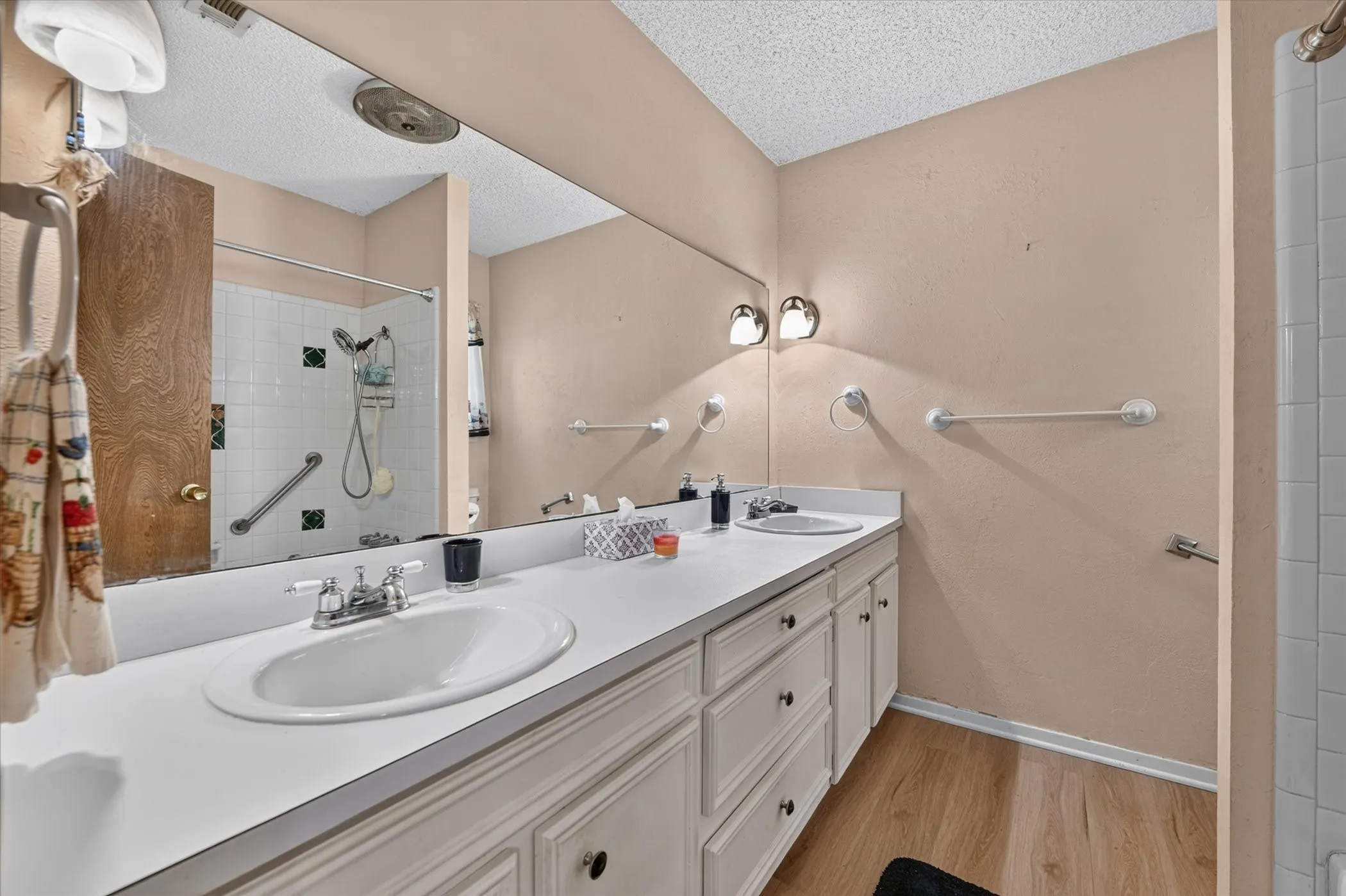 Bathroom vanity featuring dual undermount sinks with white countertops and white cabinetry