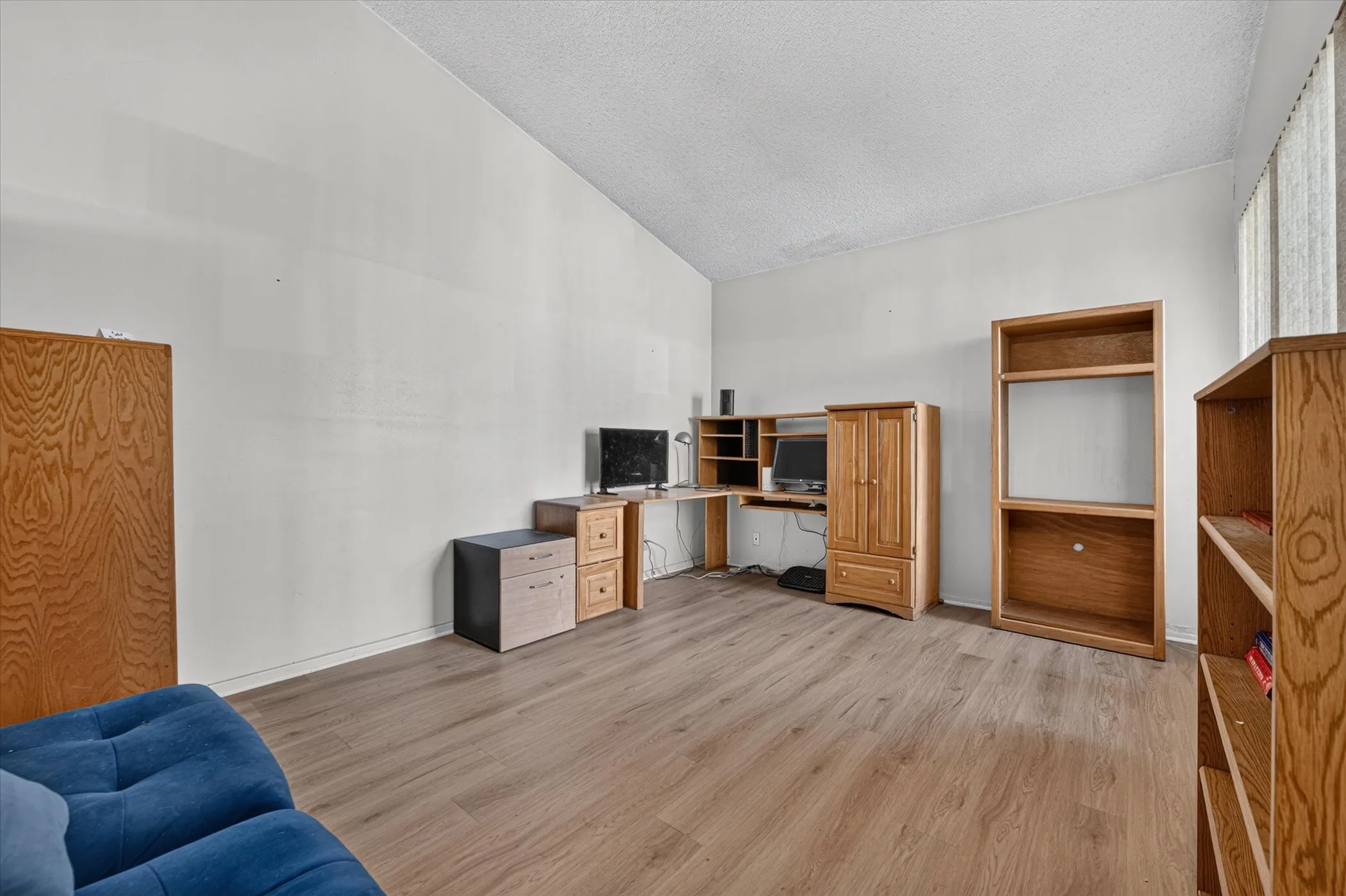 Spacious room featuring wood-finish flooring and neutral wall tones