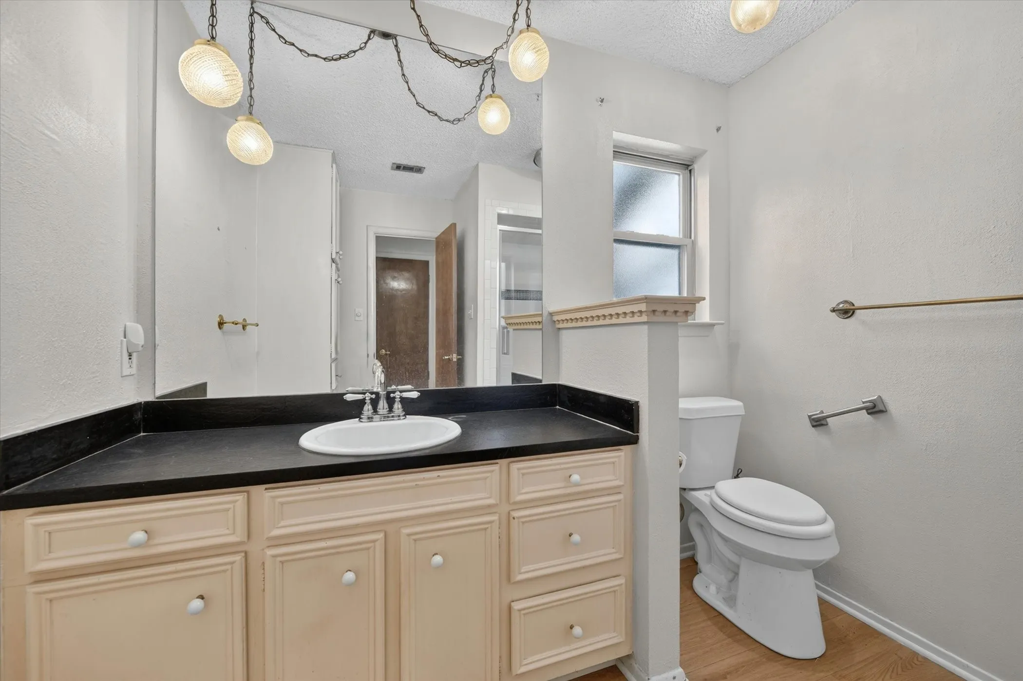Vanity with an integrated sink, dark countertop, and custom cabinetry