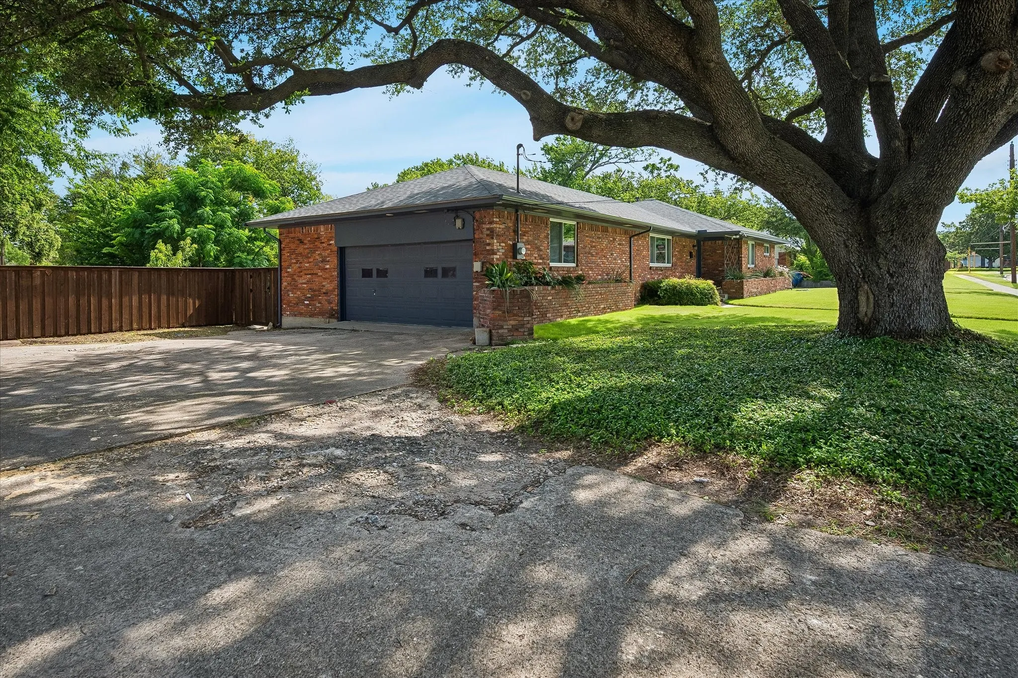 Very large driveway with space to park several cars and leading to an oversized 2 car garage with storage. The fantastic oak tree provides shade as well.