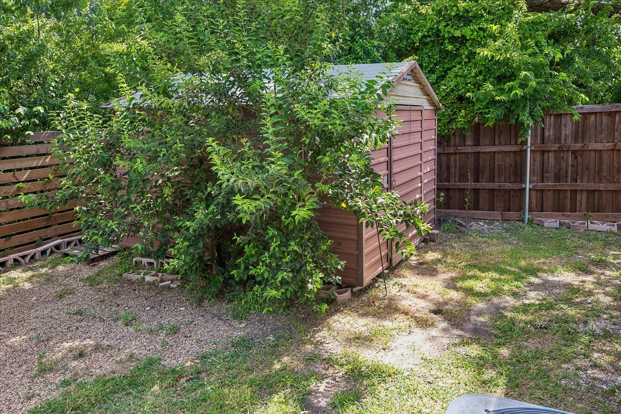 Storage shed on side of yard provides great space to keep lawn equipment, outdoor furniture, kids toys, etc.