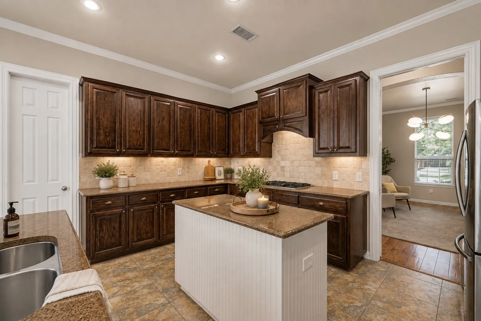 Kitchen featuring dark wood cabinetry, light tile backsplash, light-toned countertops, a center island with a beadboard base, and recessed lighting
