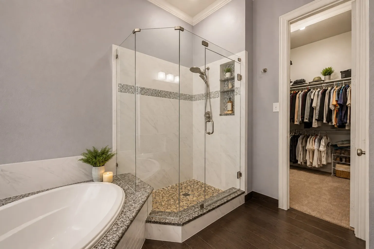 Walk-in shower with clear glass enclosure and stone pebble floor