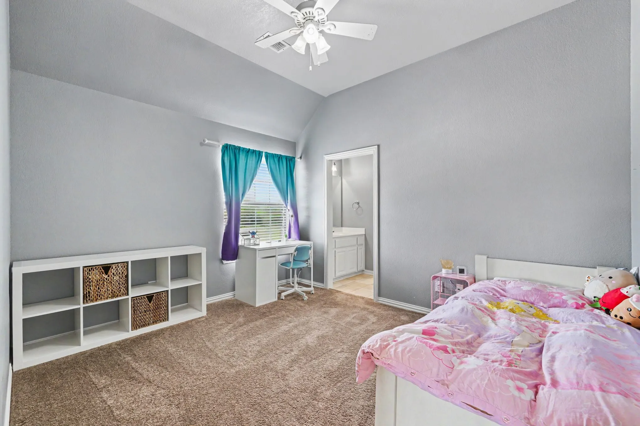 Carpeted room featuring a ceiling fan, a window with horizontal blinds, and a built-in shelving unit