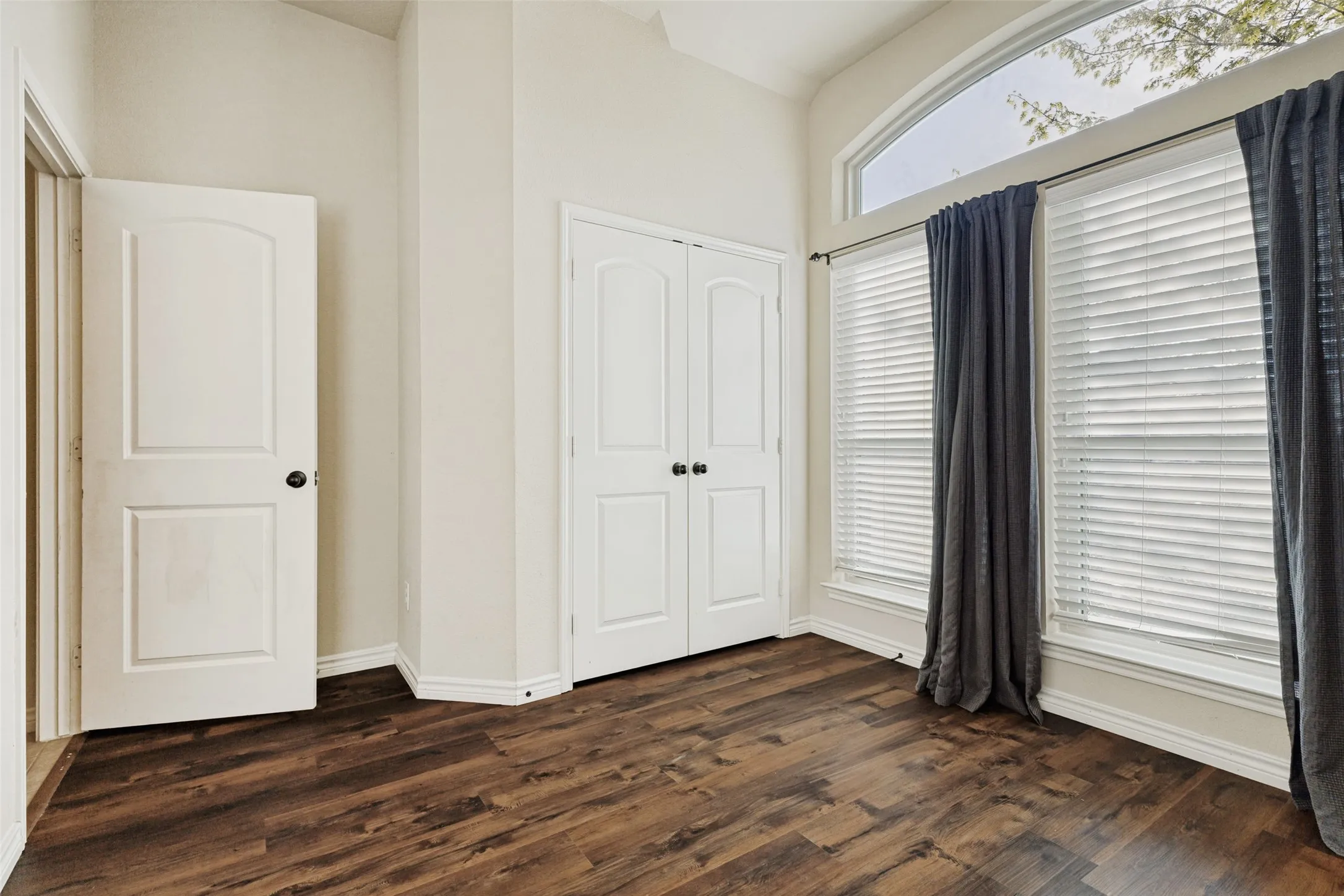 Spacious room featuring wood-finish flooring and neutral wall tones