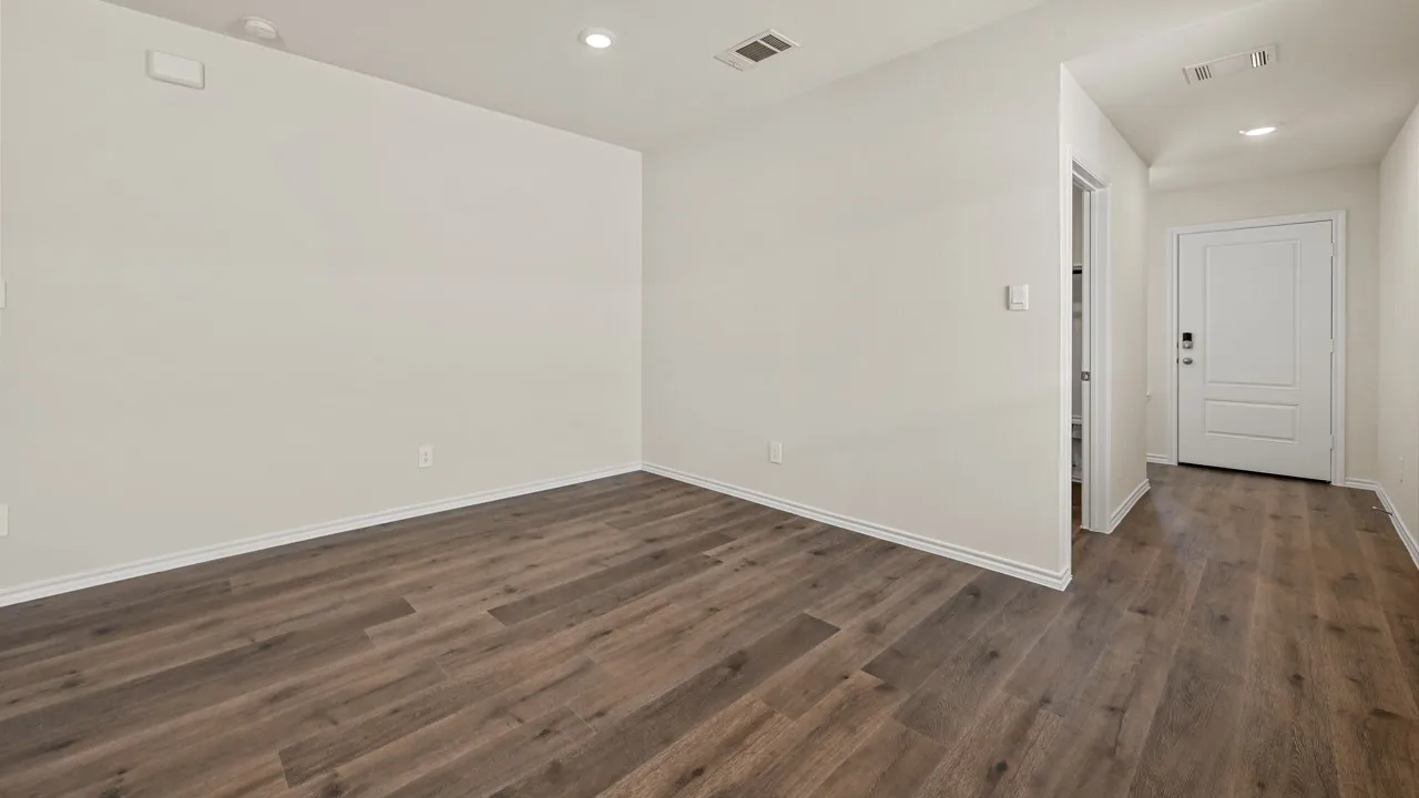 Spacious room with wood-finish flooring, recessed lighting, and a neutral color palette