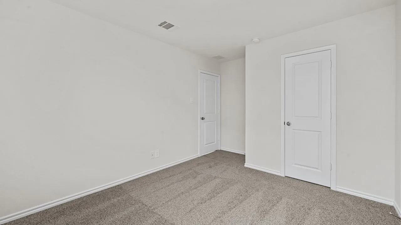 Carpeted room featuring white walls, white trim, and two paneled interior doors with round doorknobs