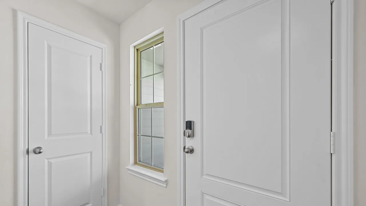 White paneled entry door with smart lock hardware