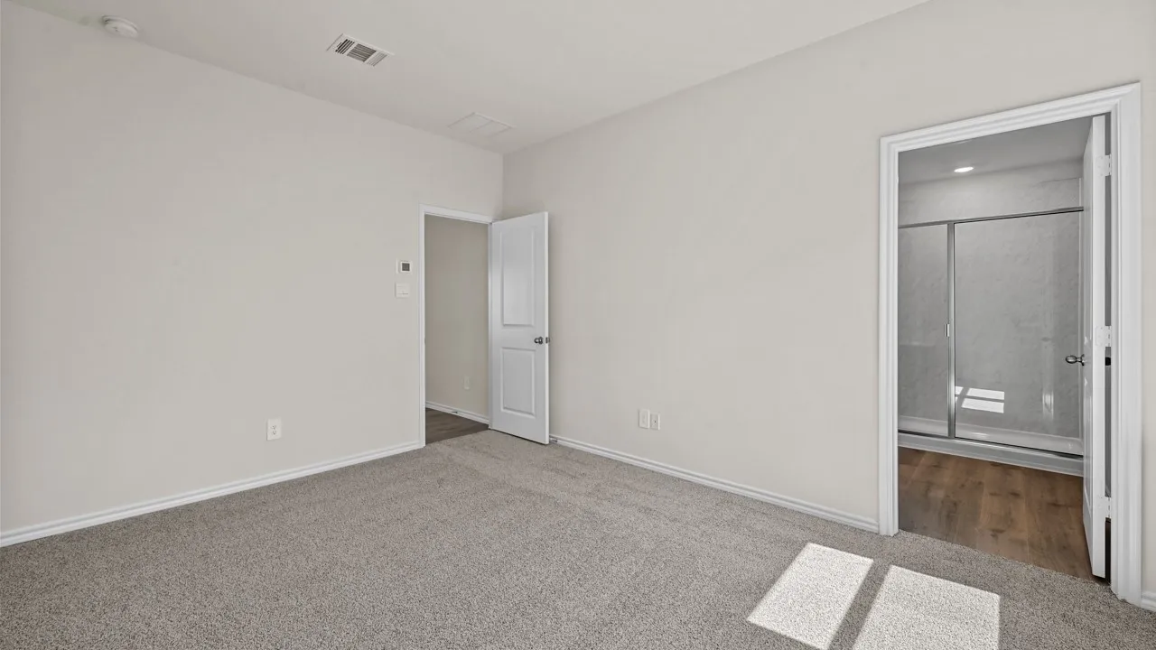 Carpeted room with light neutral walls, featuring a white door with a round knob