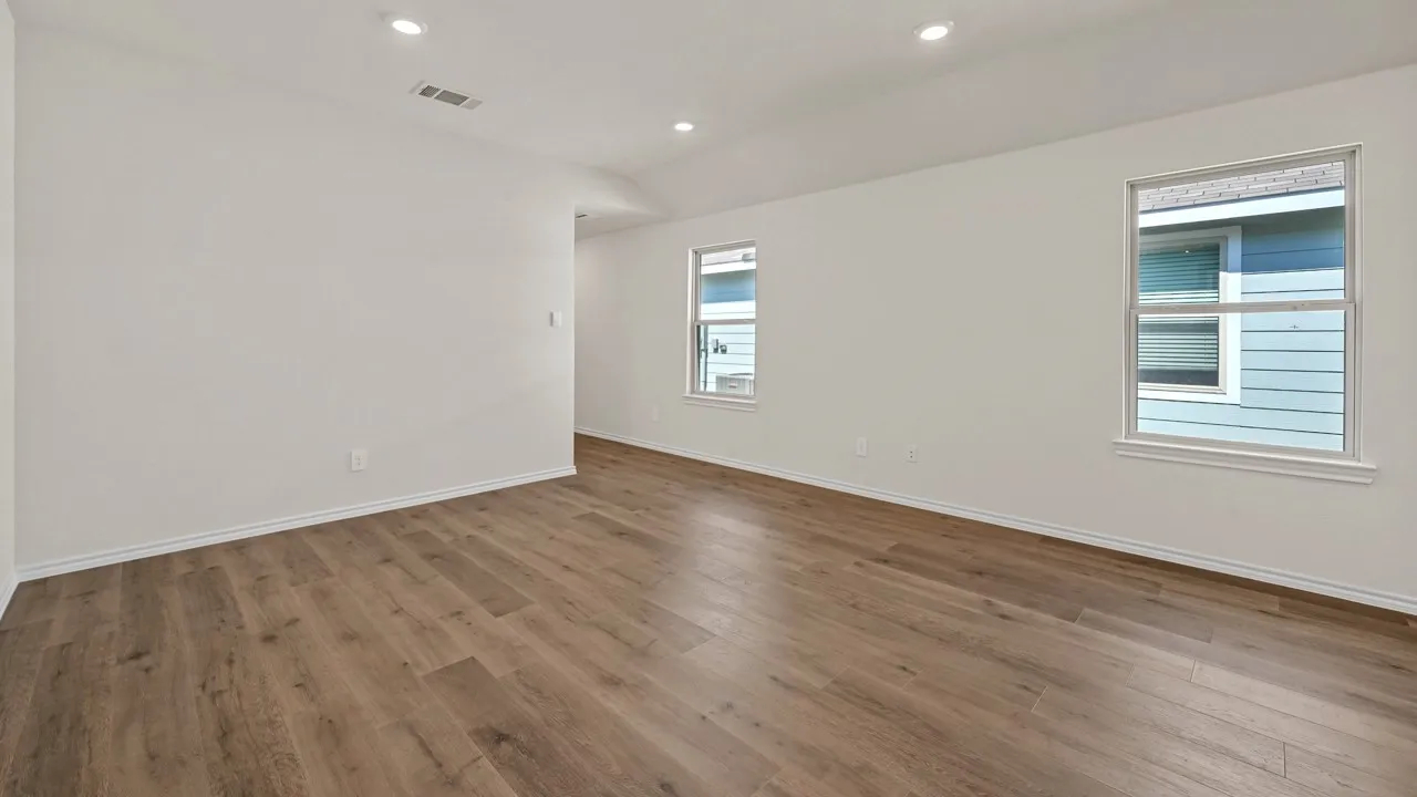 Spacious interior featuring wood-finish flooring, recessed lighting, and white baseboards