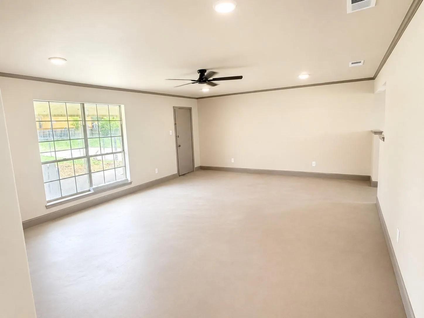 Spacious room featuring neutral-toned walls, crown molding, and recessed lighting