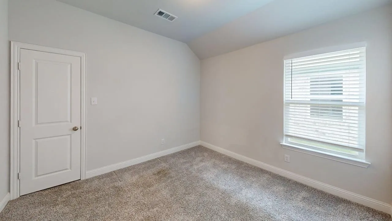Carpeted interior room with neutral wall tones