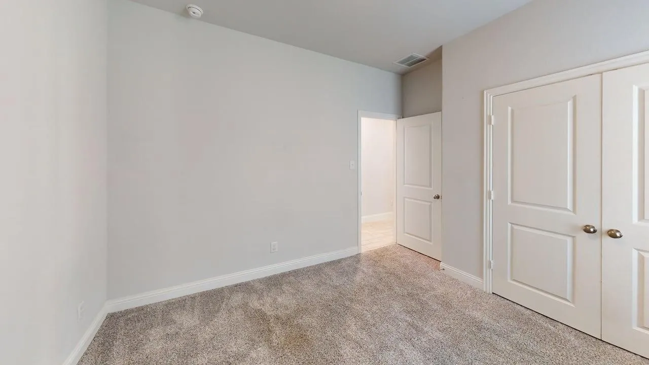 Carpeted interior room with light gray walls, white trim, and white double-panel doors