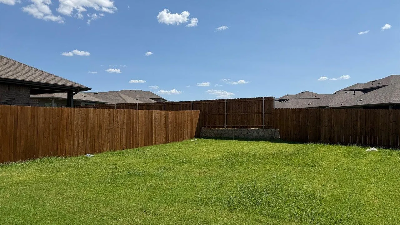 Expansive grassy yard with a privacy fence