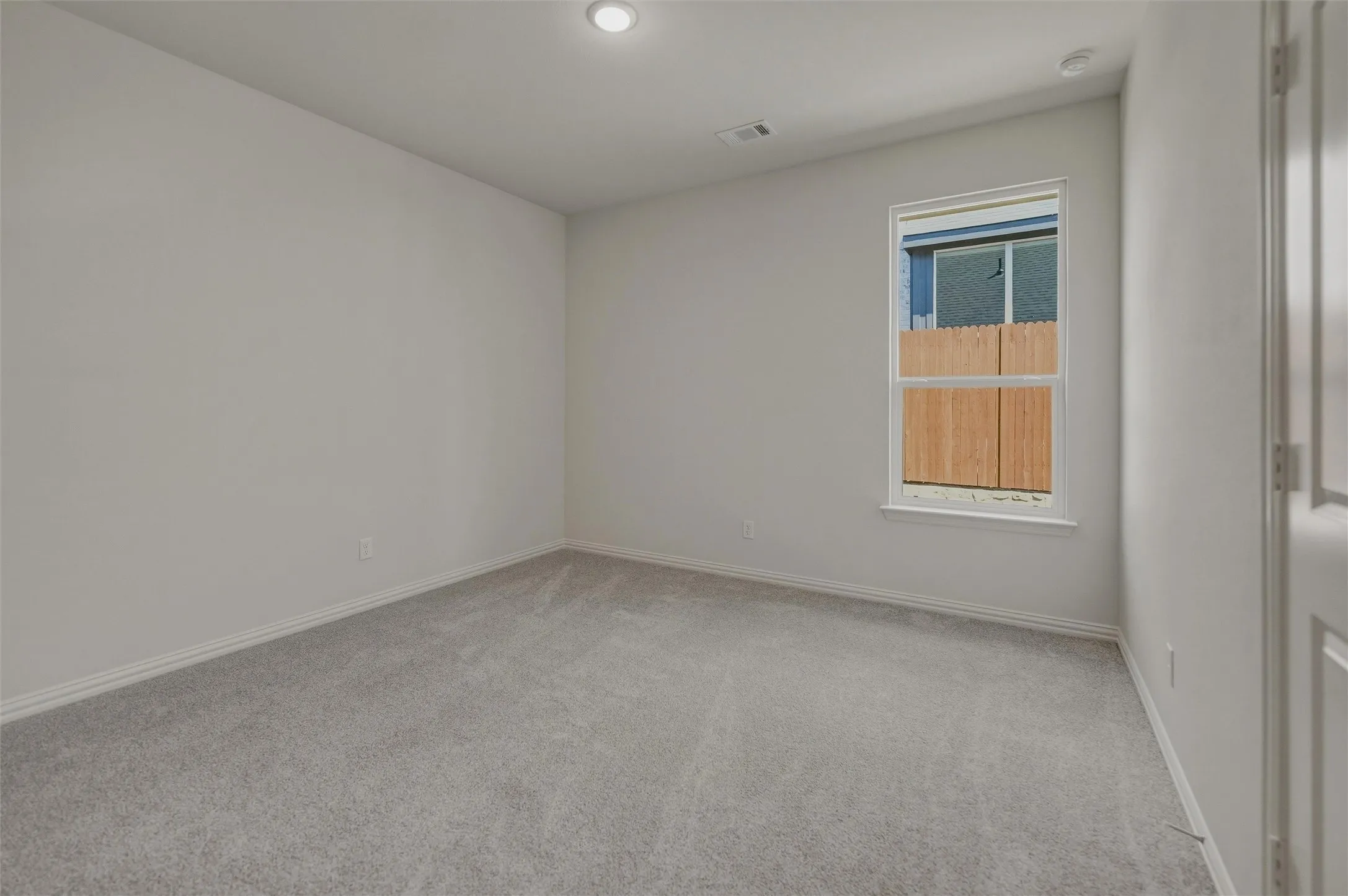 Recessed lighting, light gray carpeting, and a white interior door