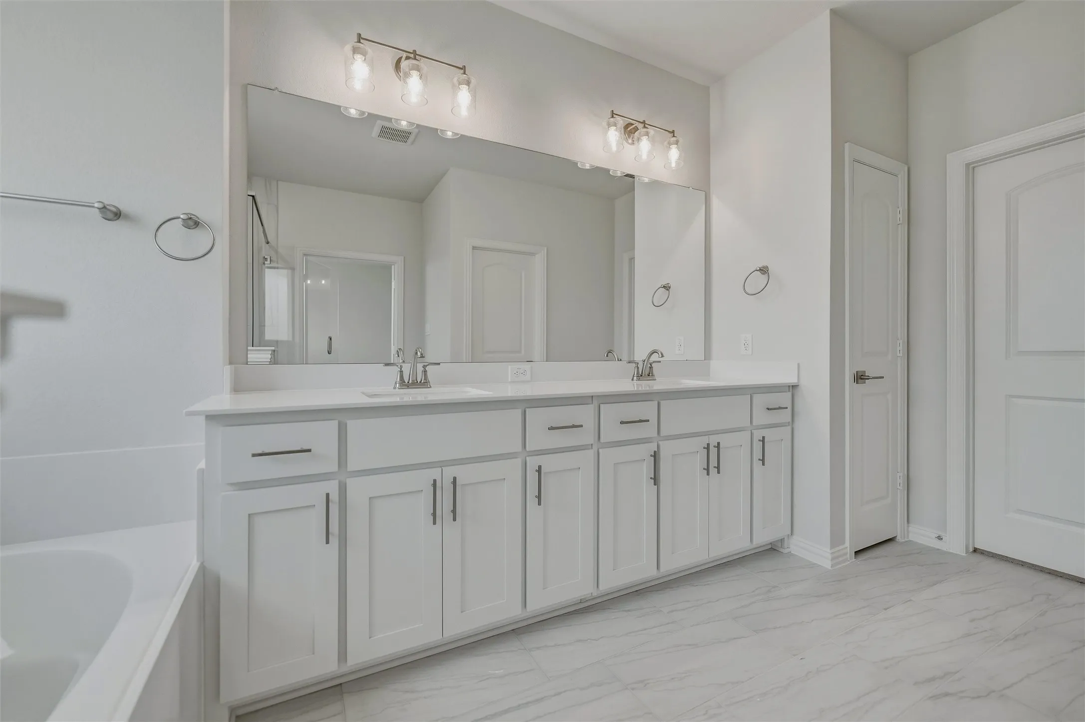 Dual vanity with undermount sinks, quartz countertop, and brushed nickel fixtures