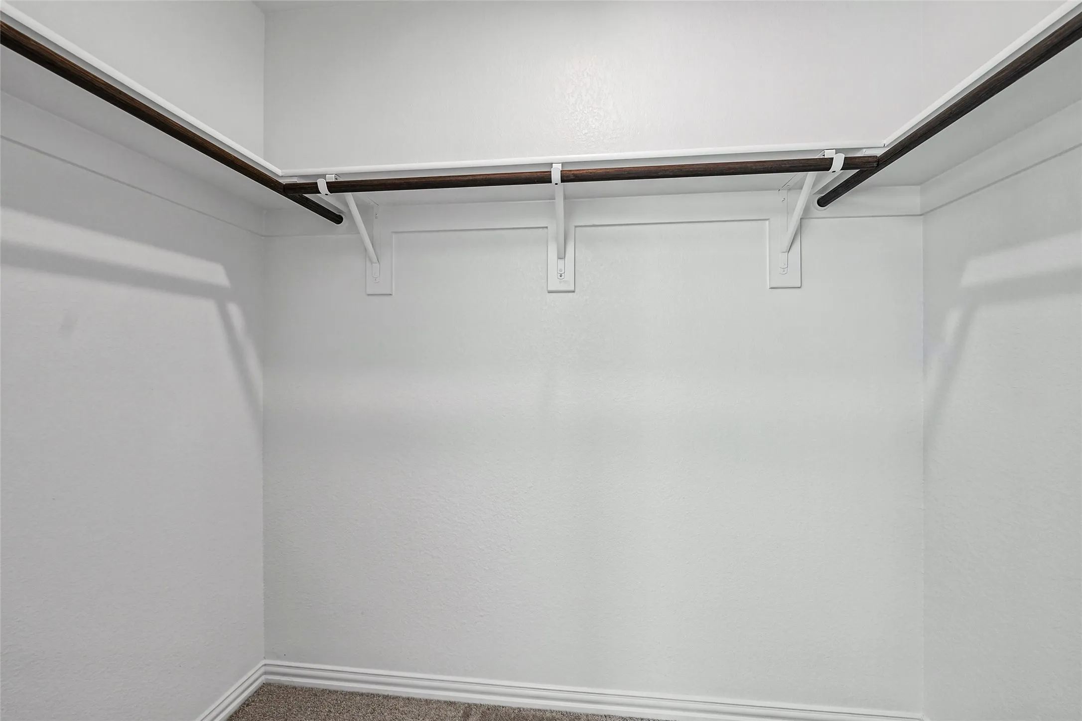 Built-in shelving with hanging rods and neutral wall color
