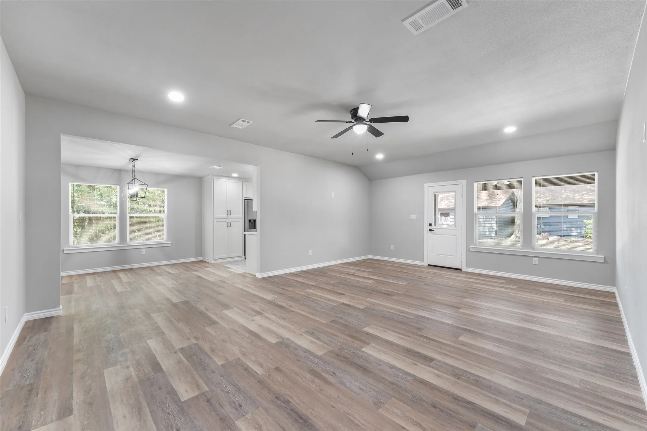 Spacious interior with wood-finish flooring, recessed lighting, and a modern ceiling fan