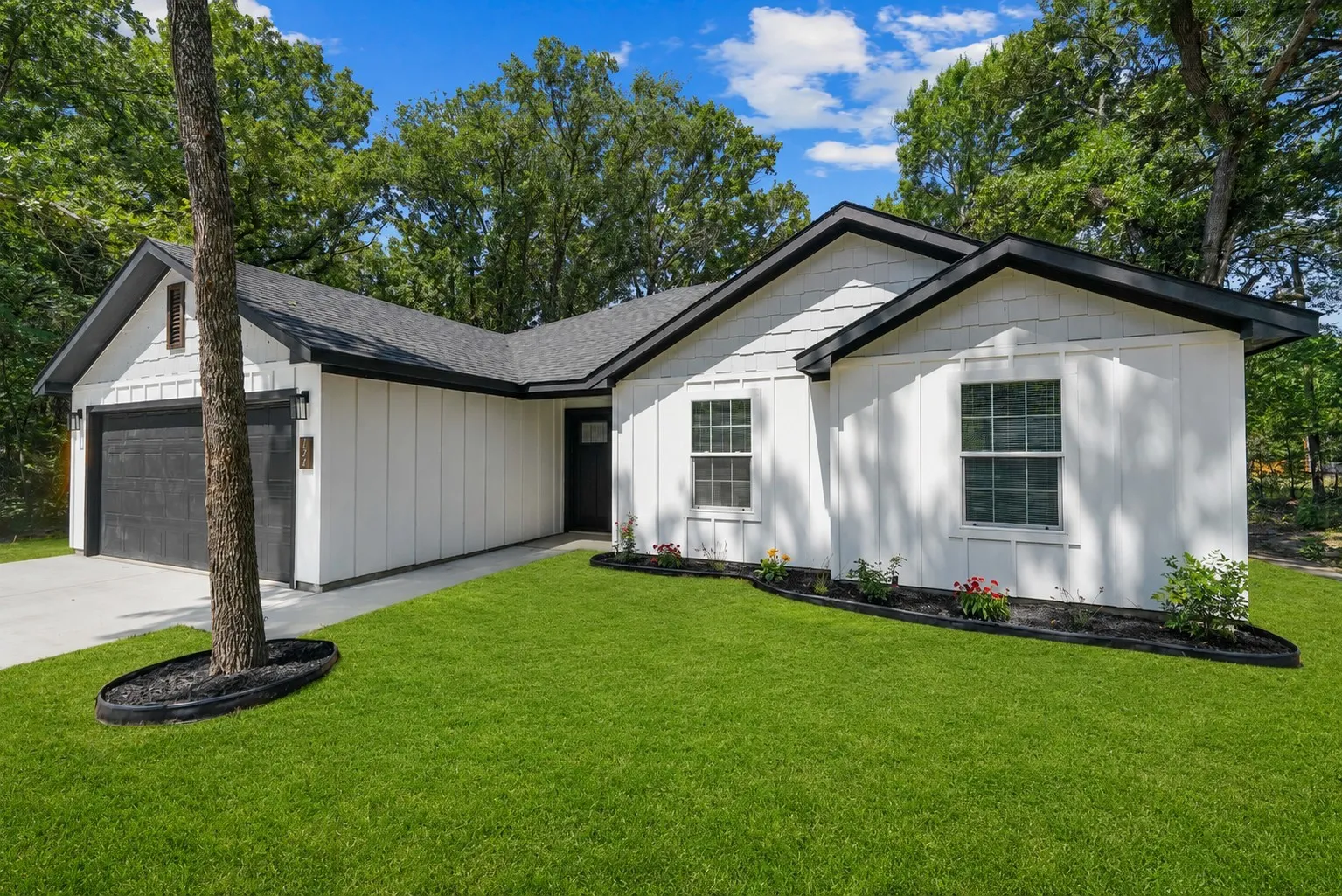 Contemporary exterior featuring white board and batten siding and black trim accents