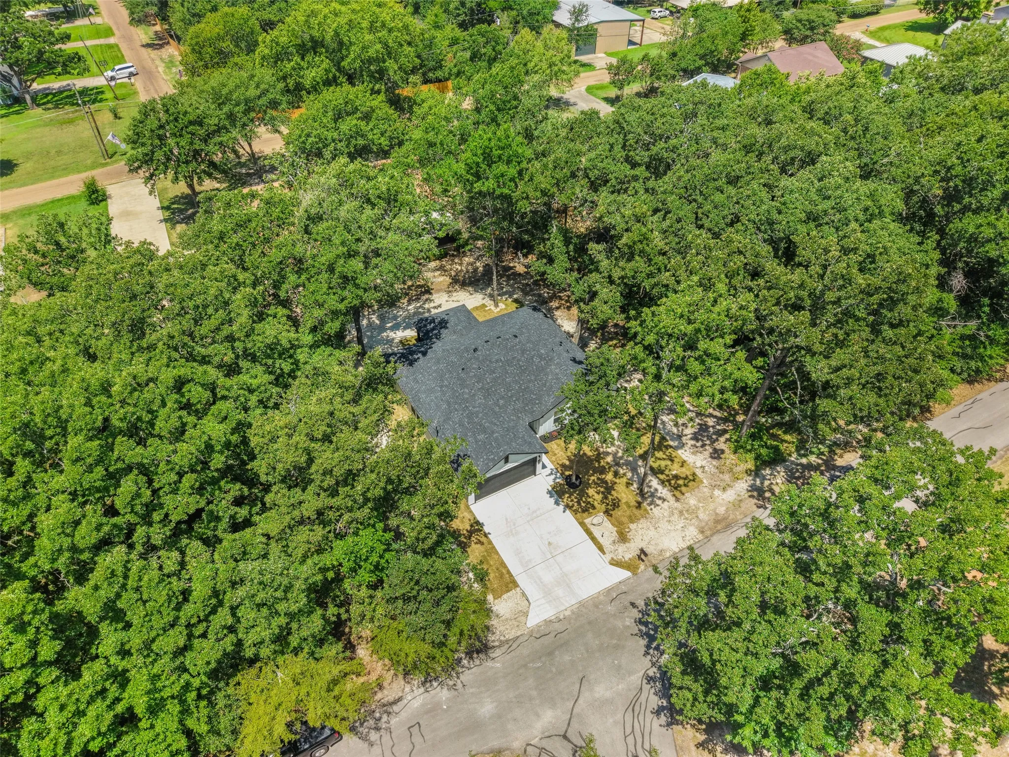 New construction residence featuring a dark shingle roof and a concrete driveway