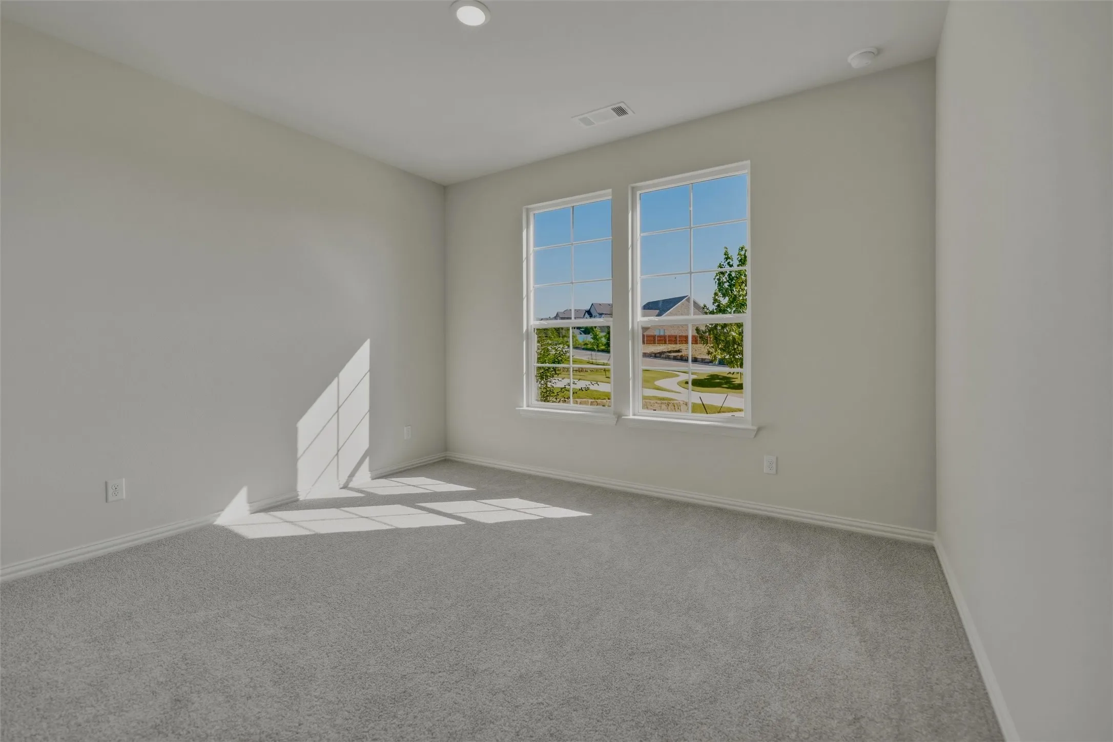 Dual pane windows, recessed lighting, neutral wall tones, and gray carpeting
